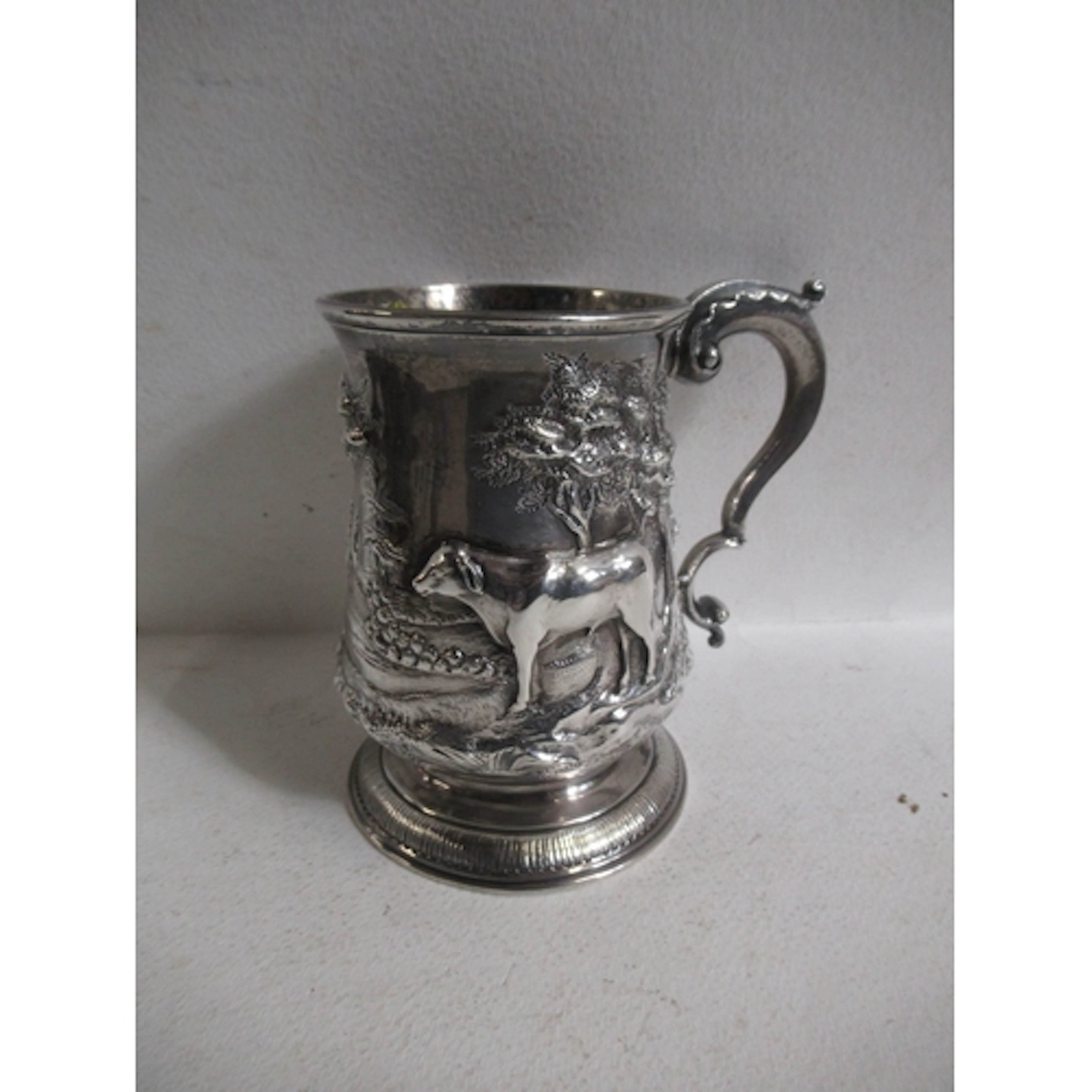 A Georgian Newcastle silver mug, with embossed decoration of...
