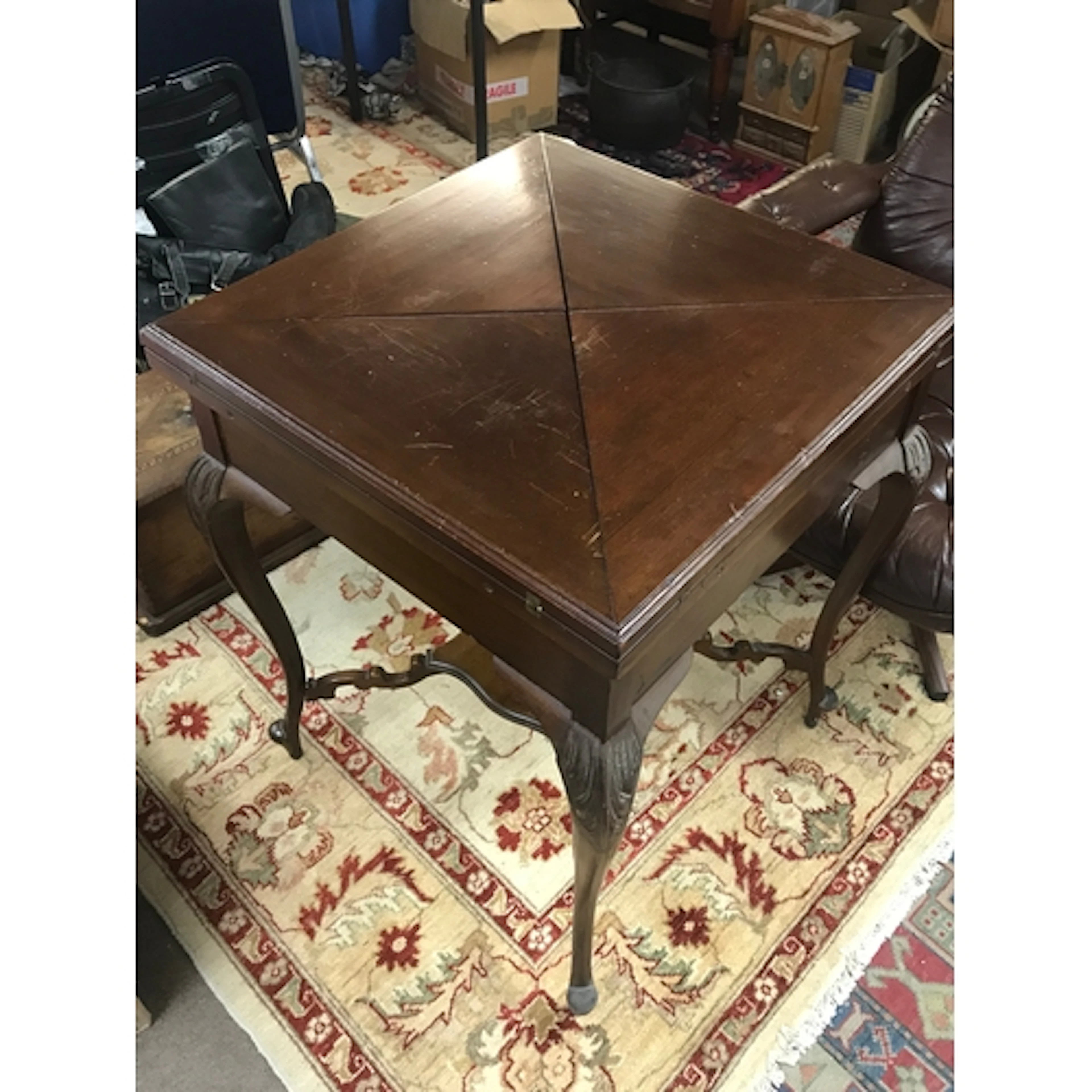 A mahogany envelope card table featuring folding triangular ...