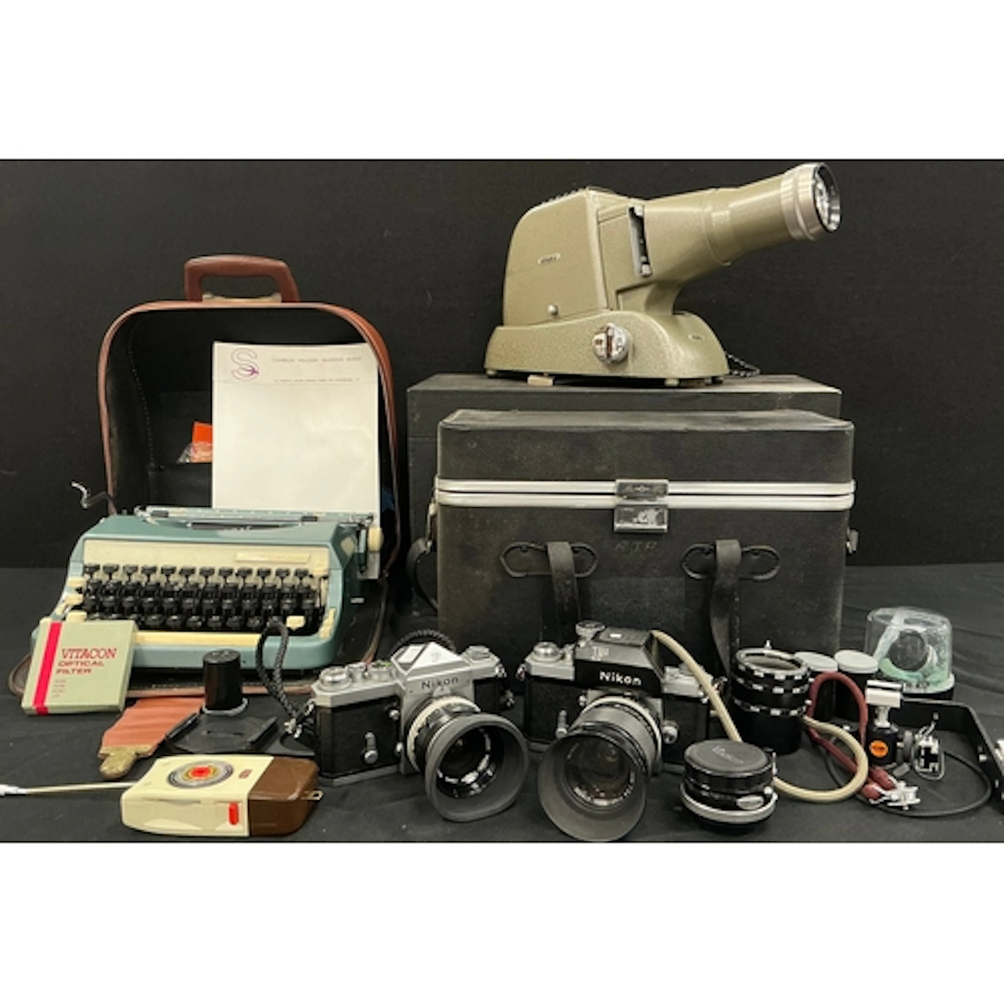 A Nikon F film camera 35mm with a rubber lens hood; another ...