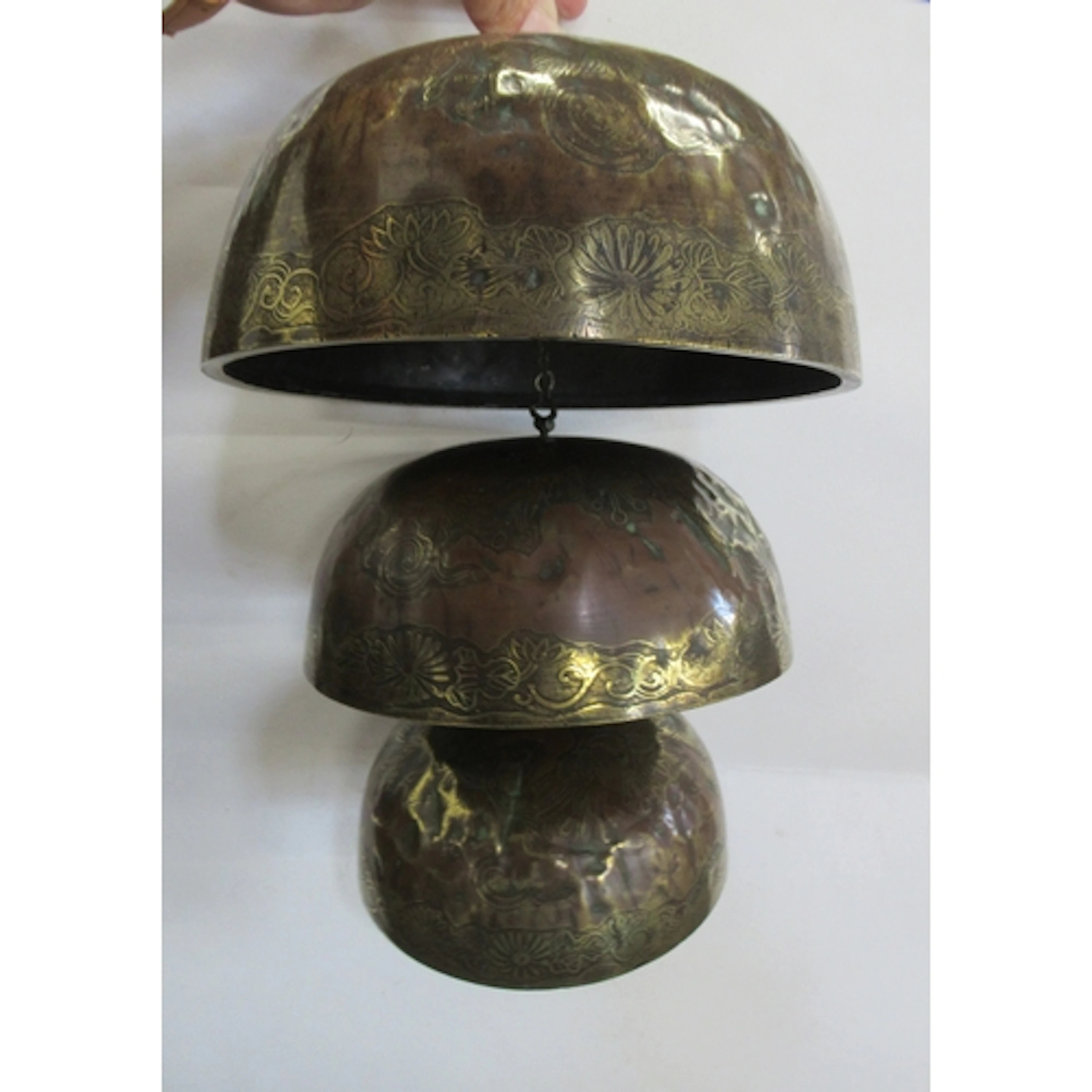 An antique hanging set of three brass graduated gongs
