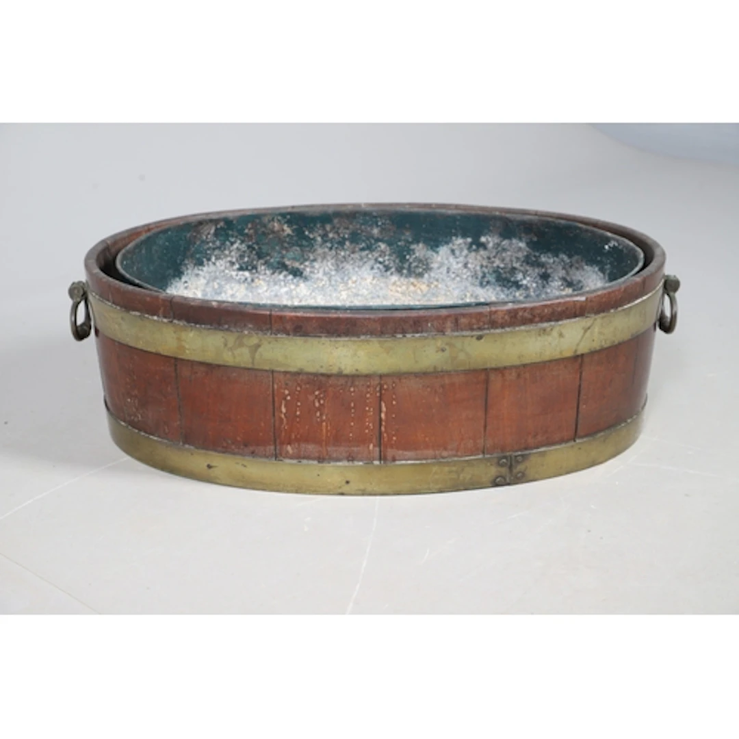 A GEORGE III OVAL COOPERED OAK JARDINIERE. brass bound with ...