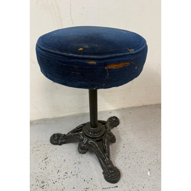 A black painted cast iron piano stool with blue velvet seat....