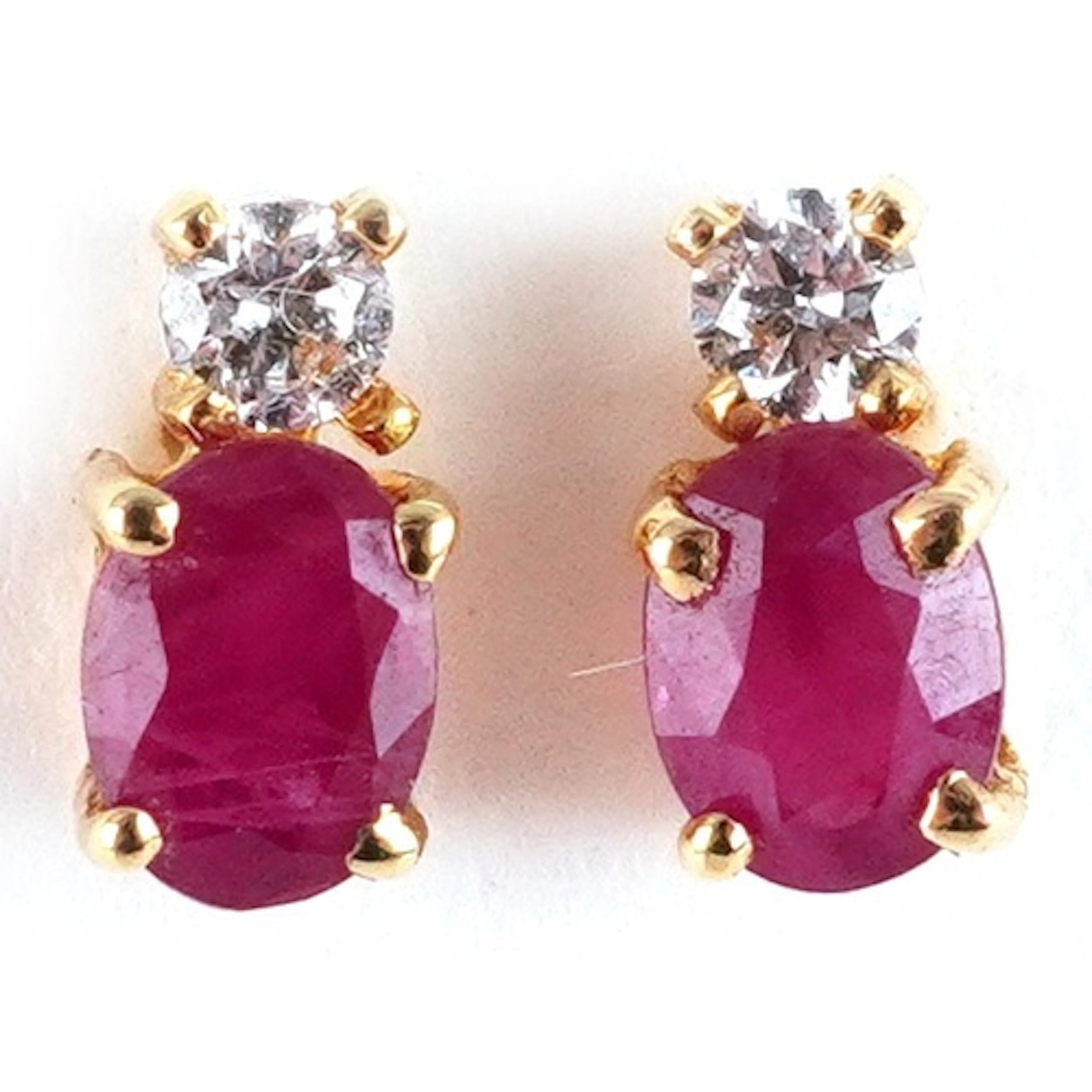 Pair of yellow metal ruby and clear stone stud earrings, the...