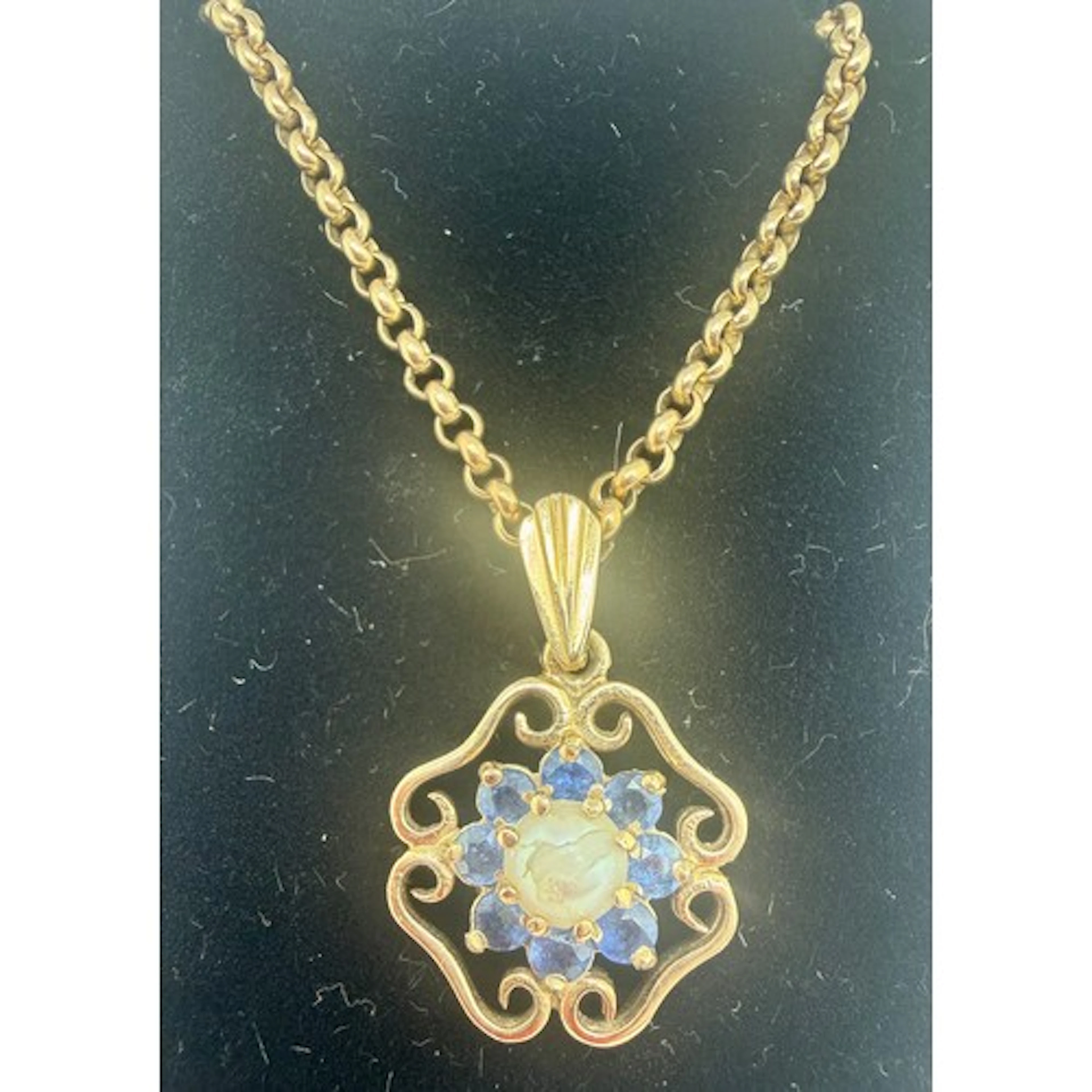 A 9 carat gold pendant set with pearl and sapphires suspende...