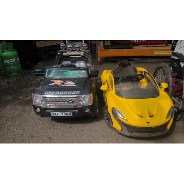 A pair of children’s ride-on battery-powered vehicles: a bla...