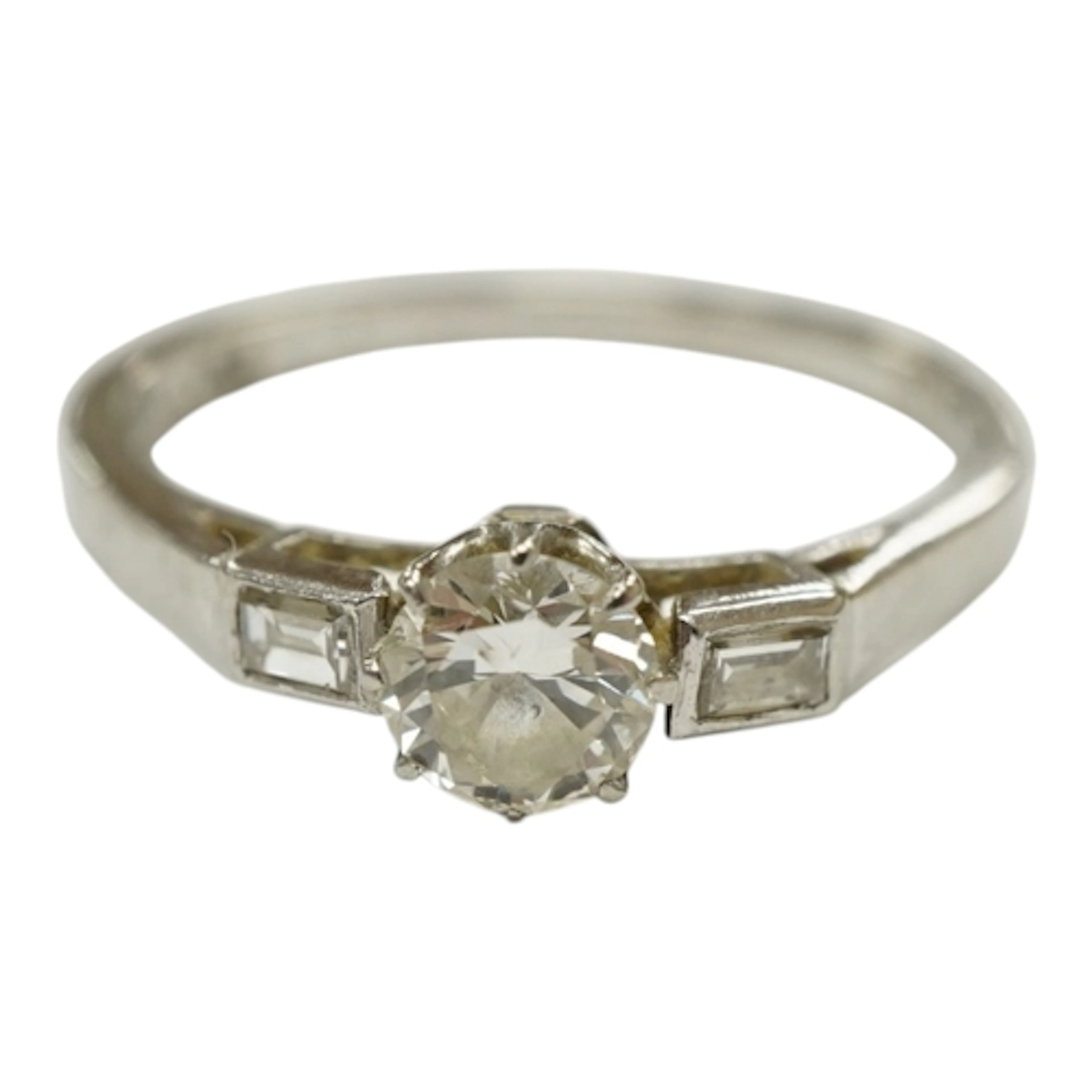 A white metal and single stone diamond set ring with baguett...