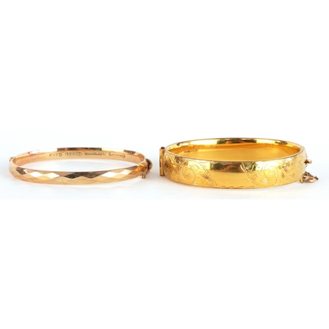 Two 9ct gold metal core hinged bangles, one with engraved de...