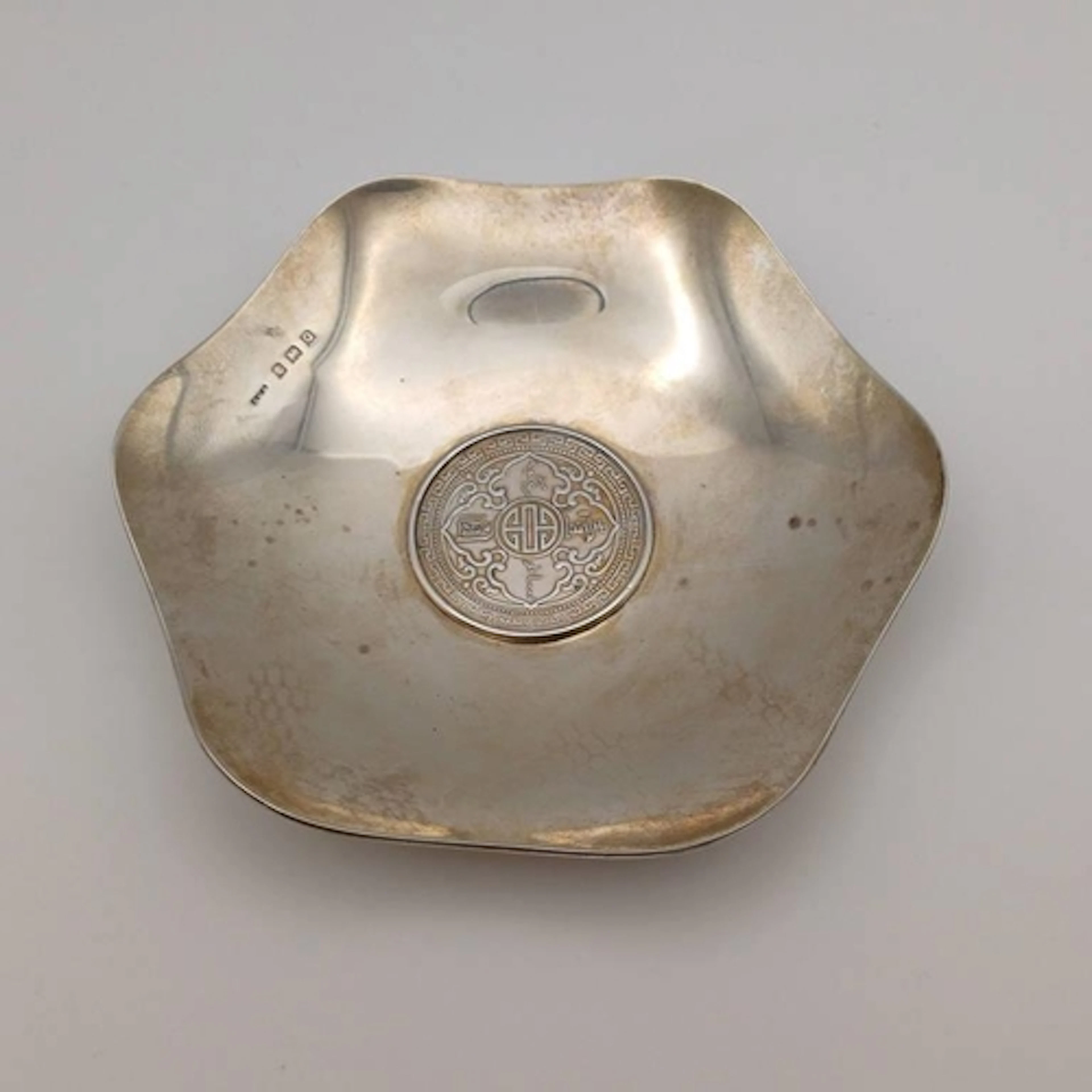A SILVER PIN DISH SET WITH A 1929 TRADE DOLLAR BY ERNEST W H...