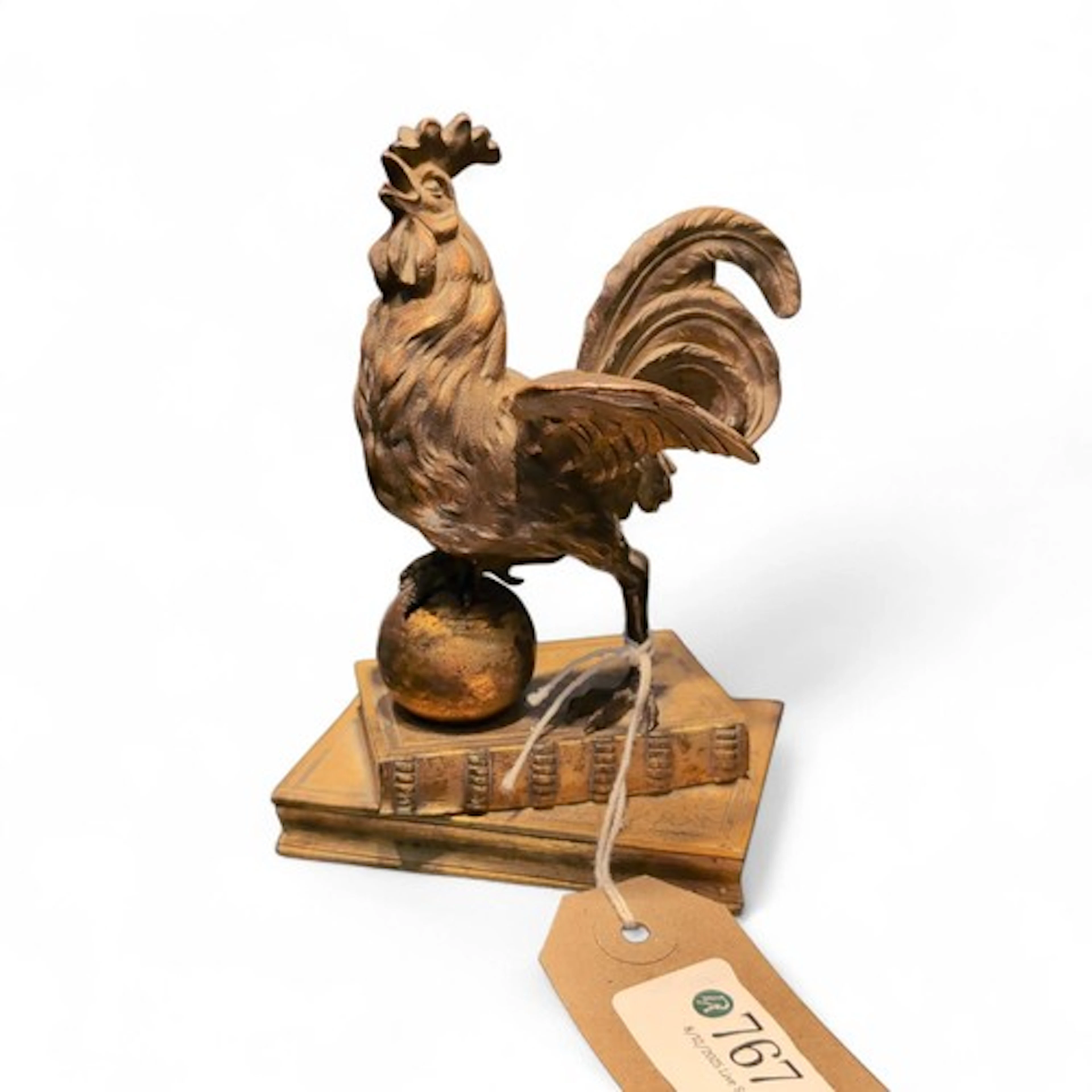 Bronze rooster figure mounted on a stack of books with one f...