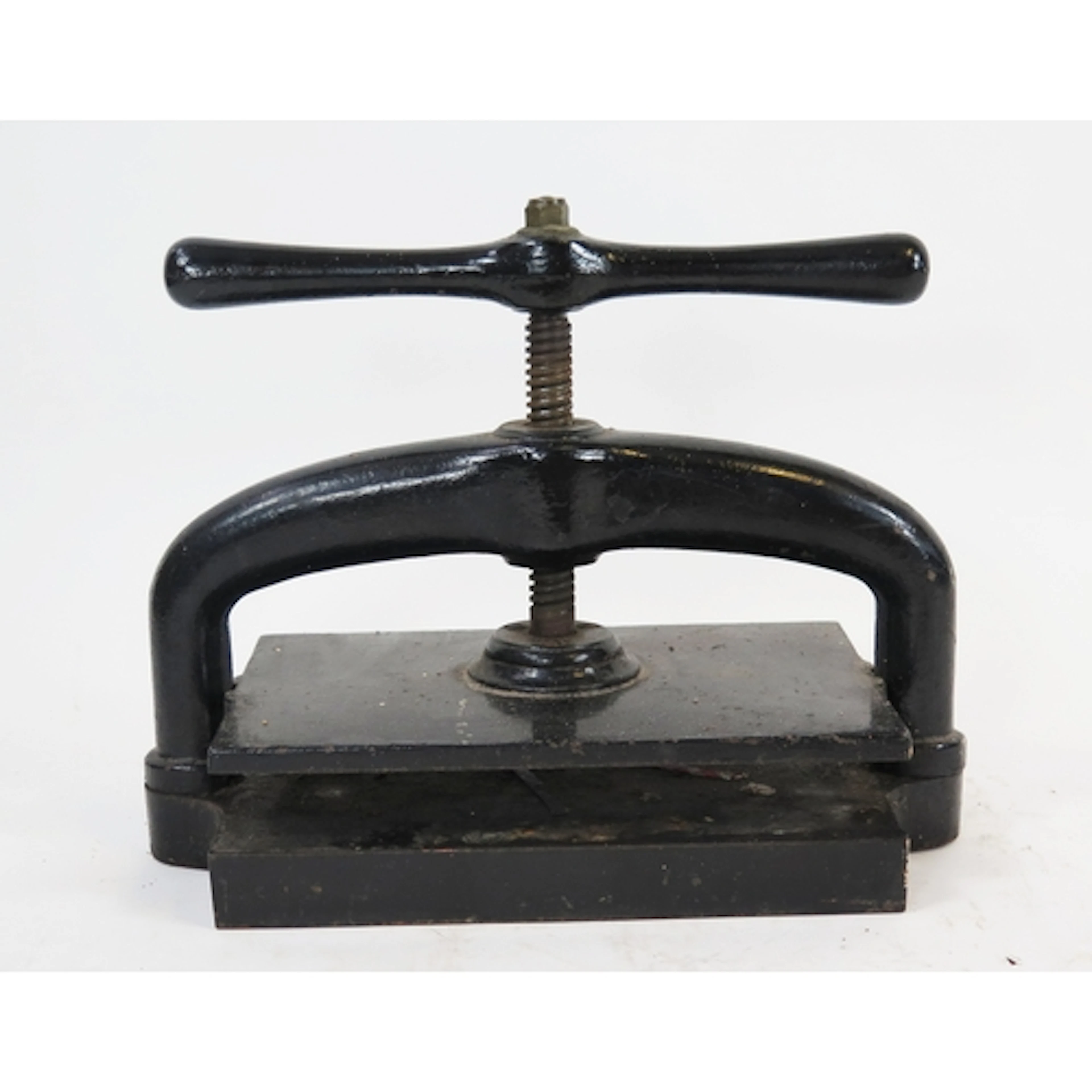 A black painted metal book press, with rectangular plate and...