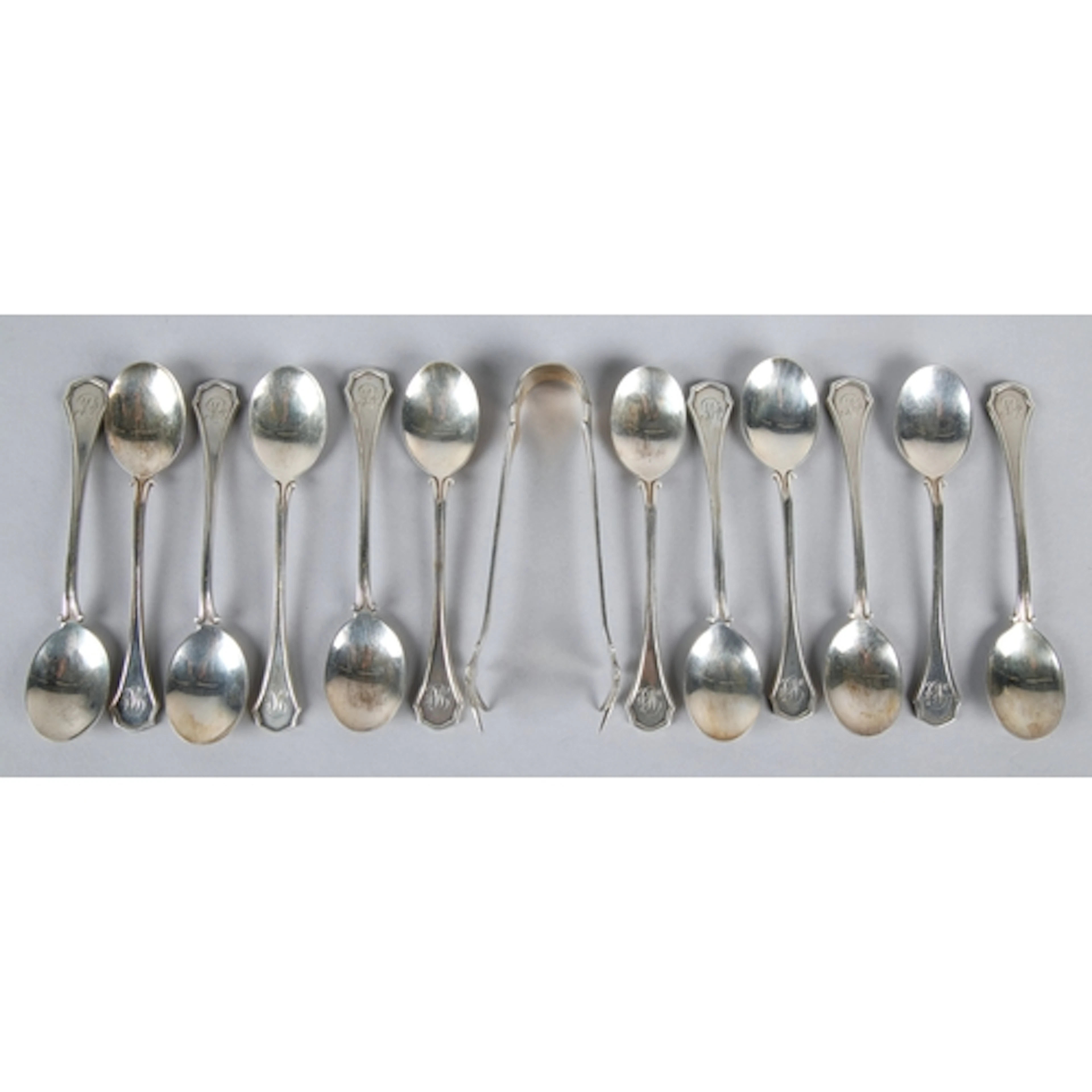 Set of twelve silver monogrammed tea spoons and sugar tongs,...