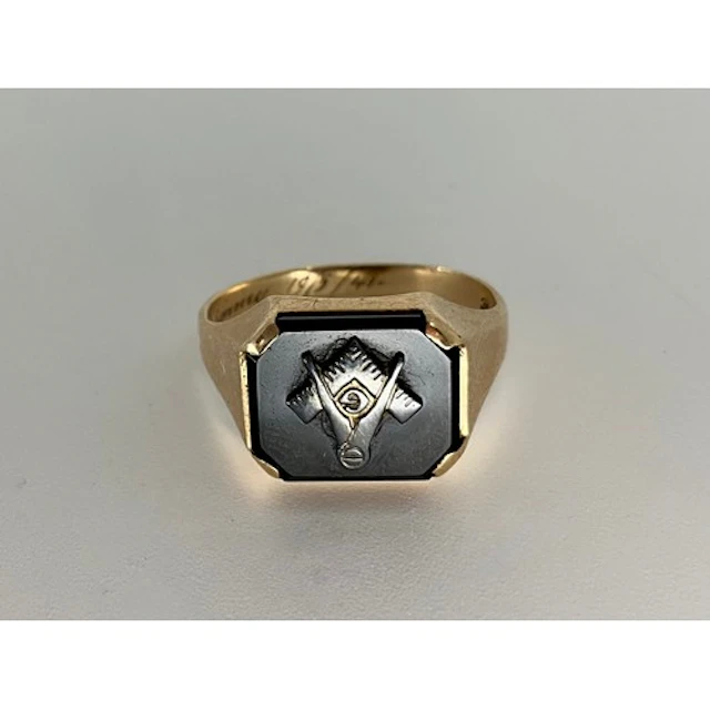 A masonic signet ring, square and compass crest on black ony...