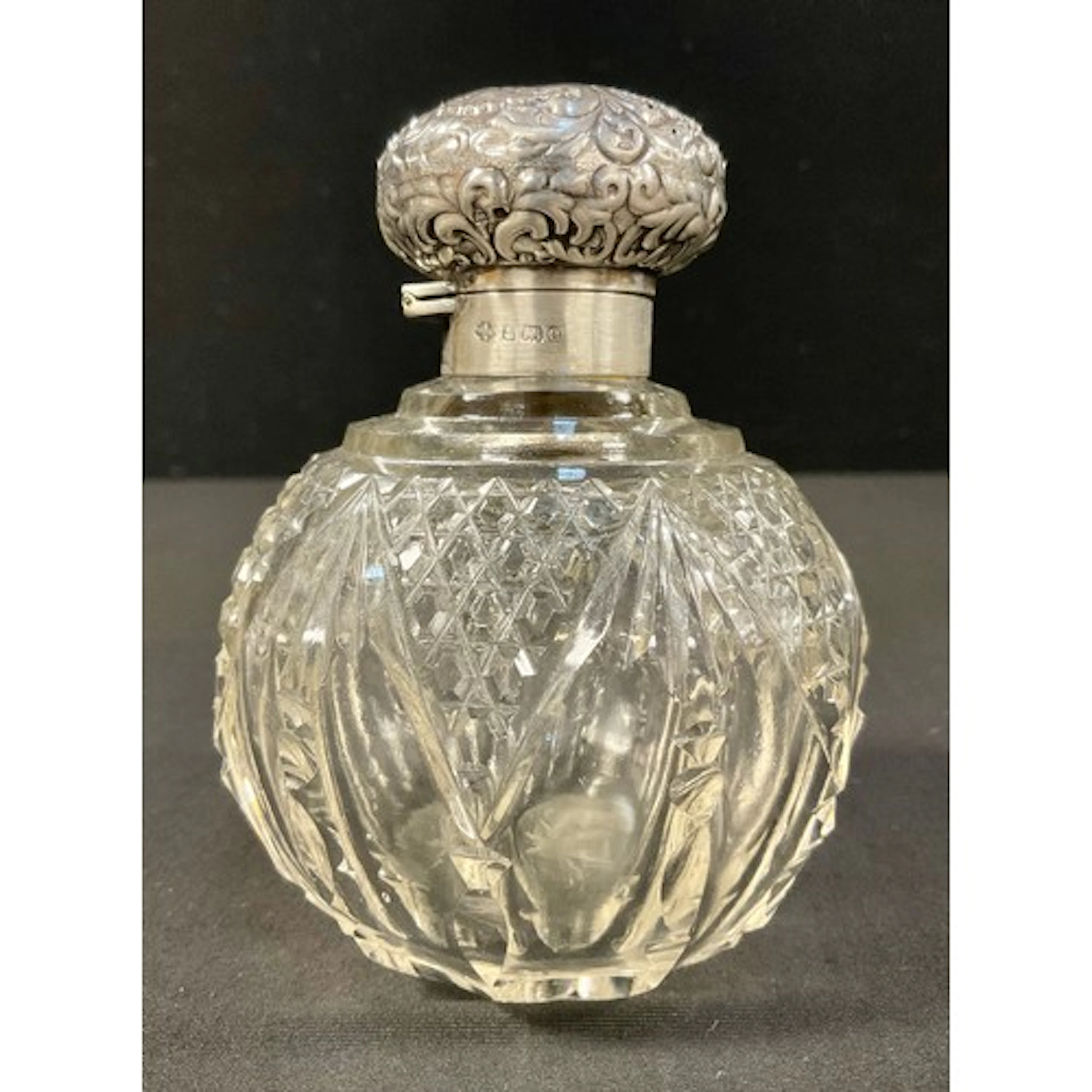 An Edwardian cut glass globular scent bottle, drop-in stoppe...
