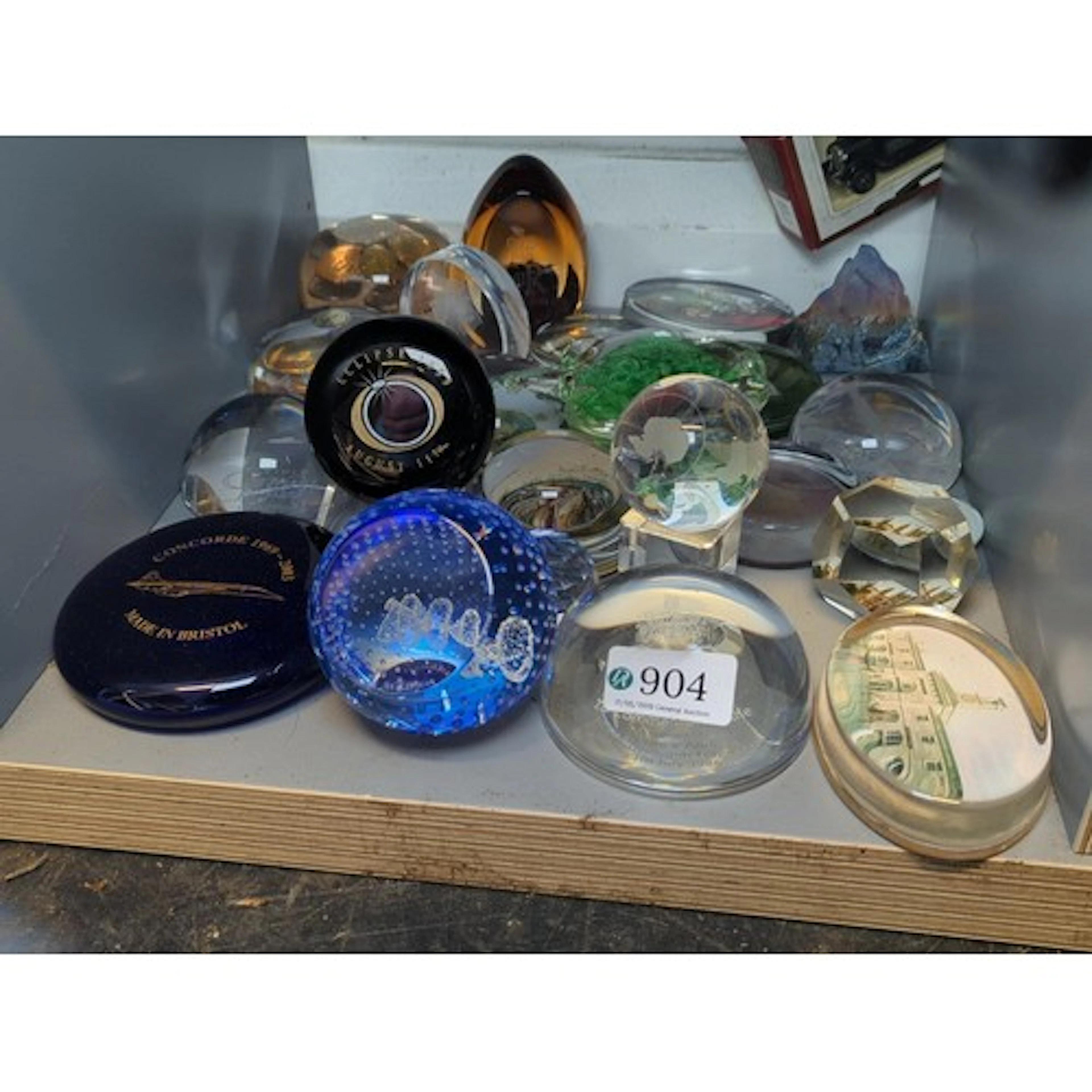 A group of souvenir glass paperweights, comprising faceted a...
