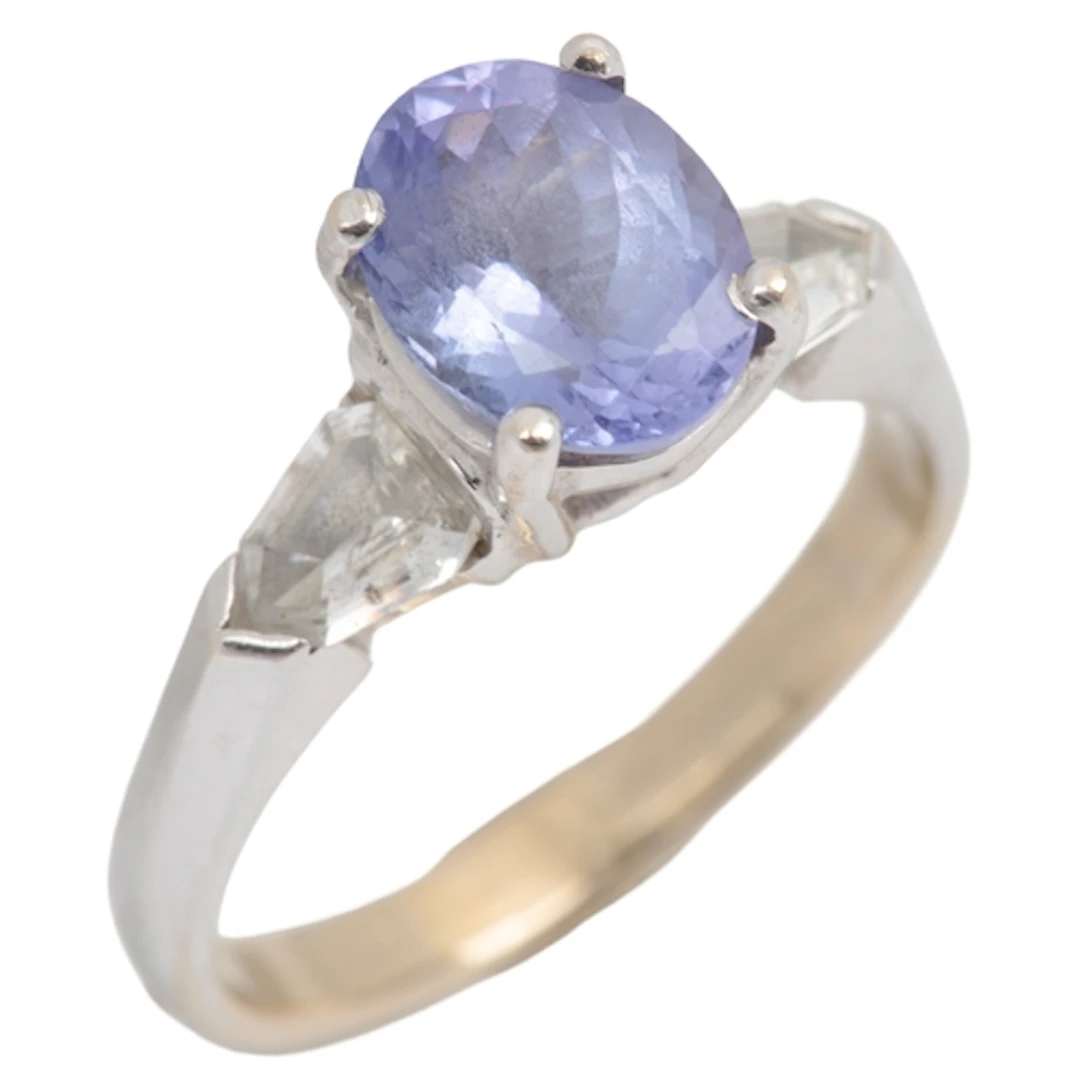 A tanzanite and diamond ring, claw-set with an oval tanzanit...