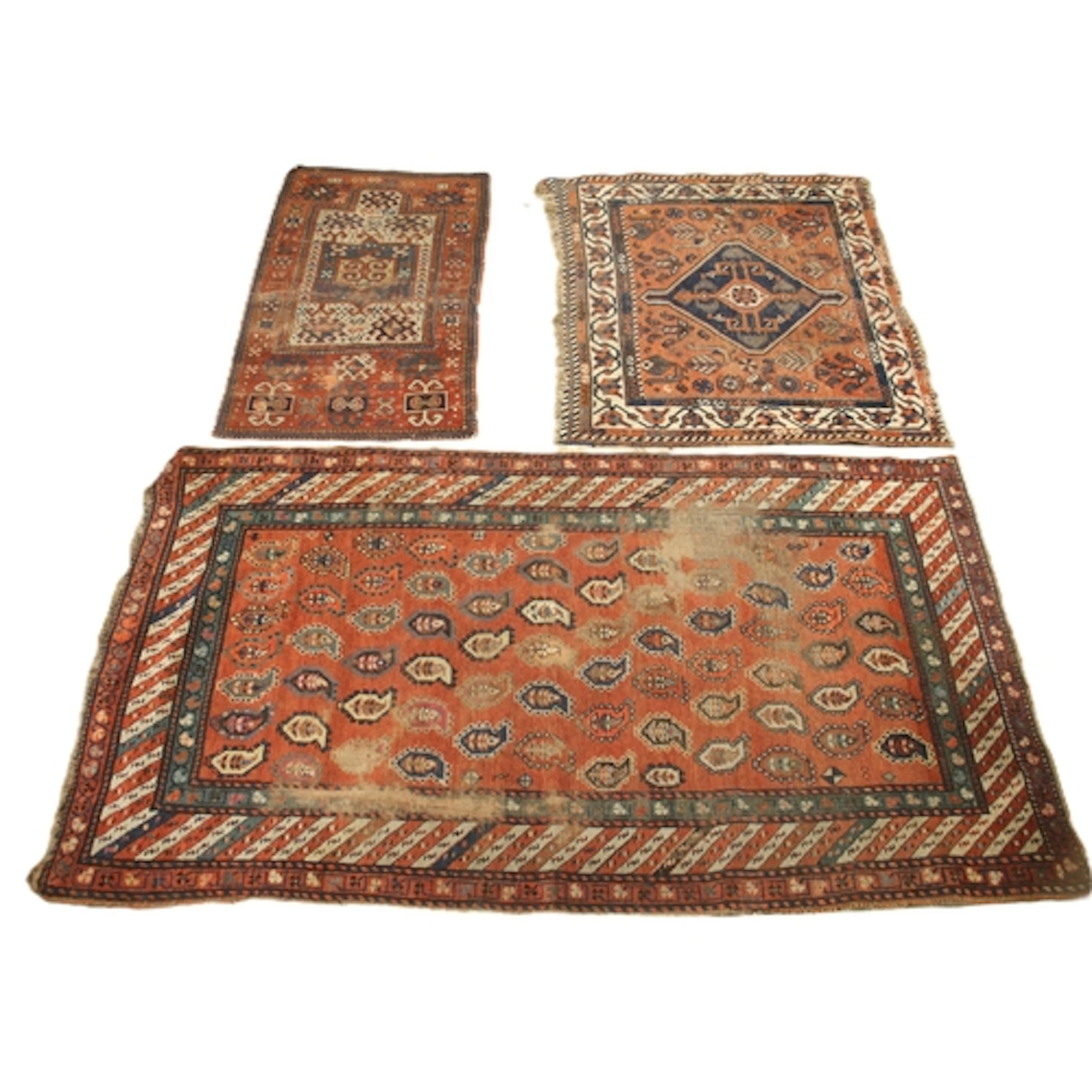 Three Caucasian hand knotted village rugs, each in red, blue...