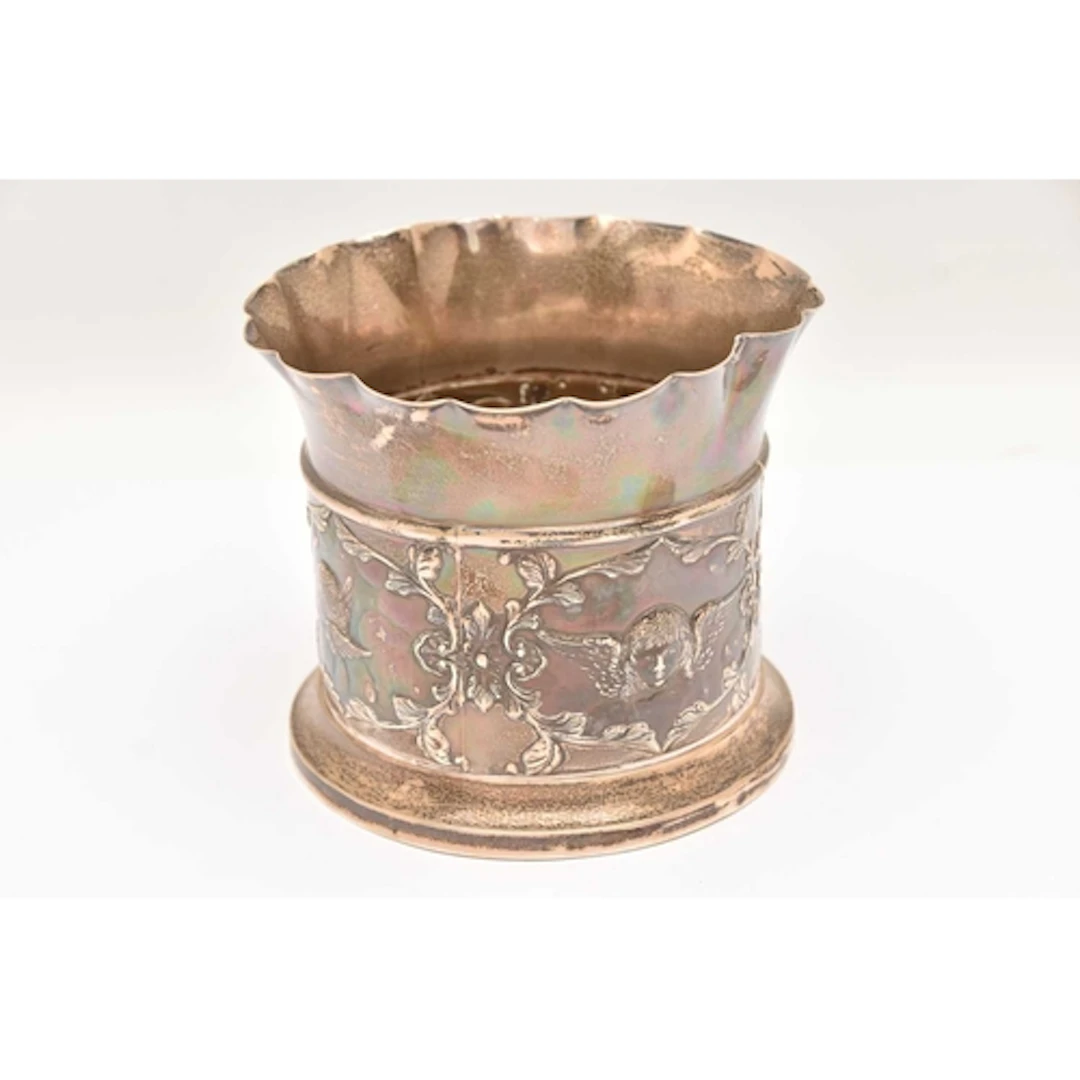 A LATE VICTORIAN SILVER BOTTLE COASTER, repousse decoration ...