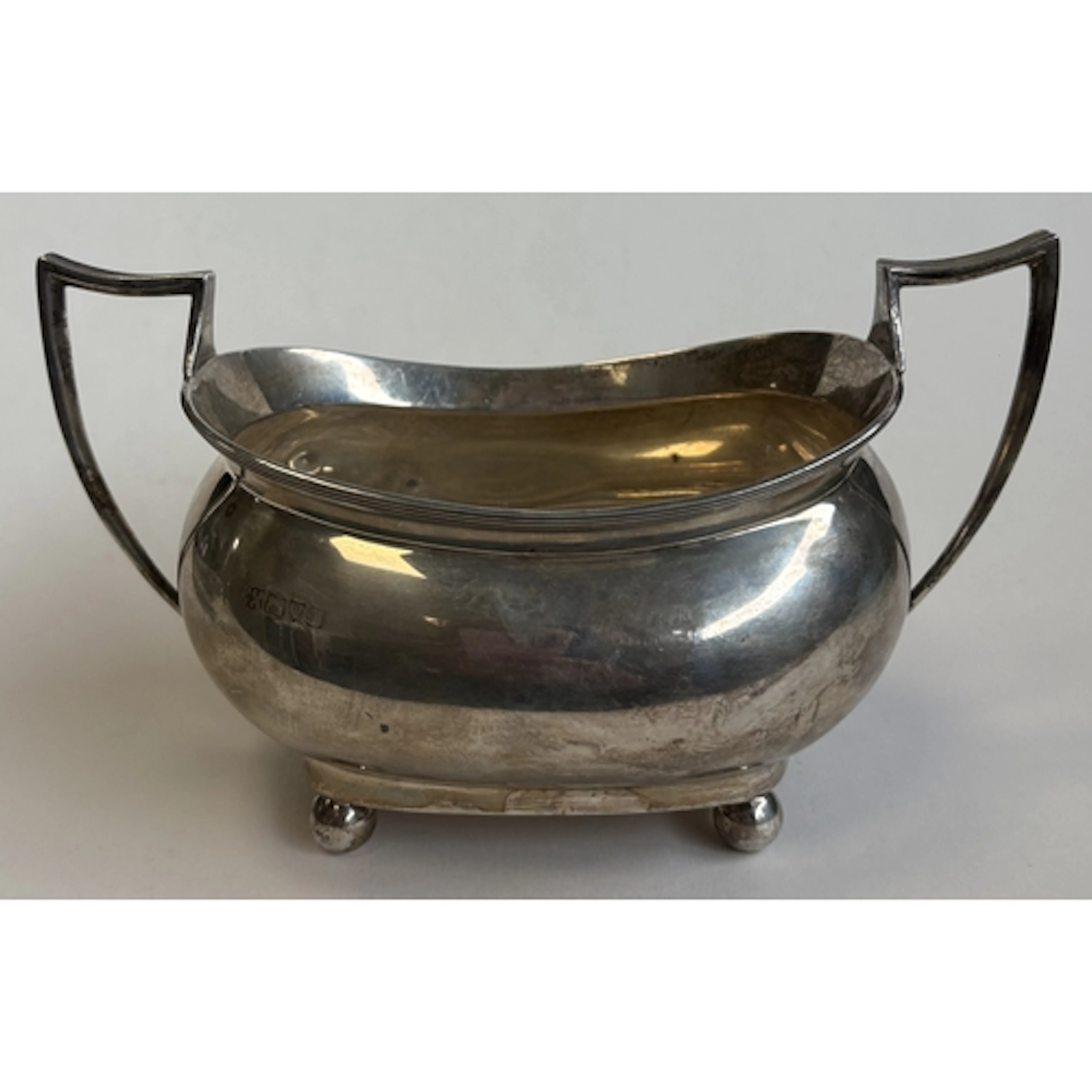 A boat-shaped Georgian silver sugar bowl on ball feet. Londo...