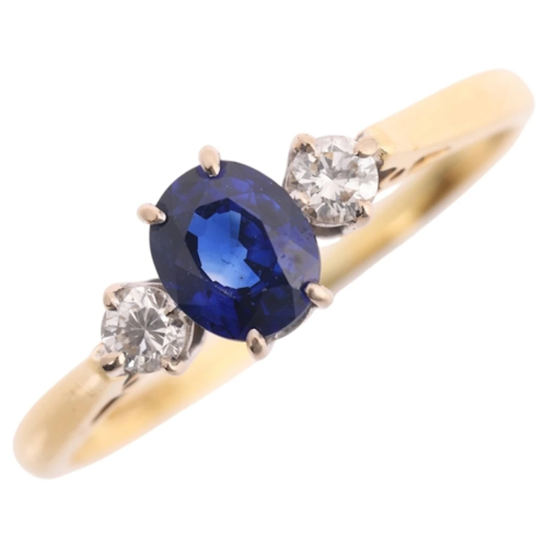 An 18ct gold three stone sapphire and diamond ring, maker CG...