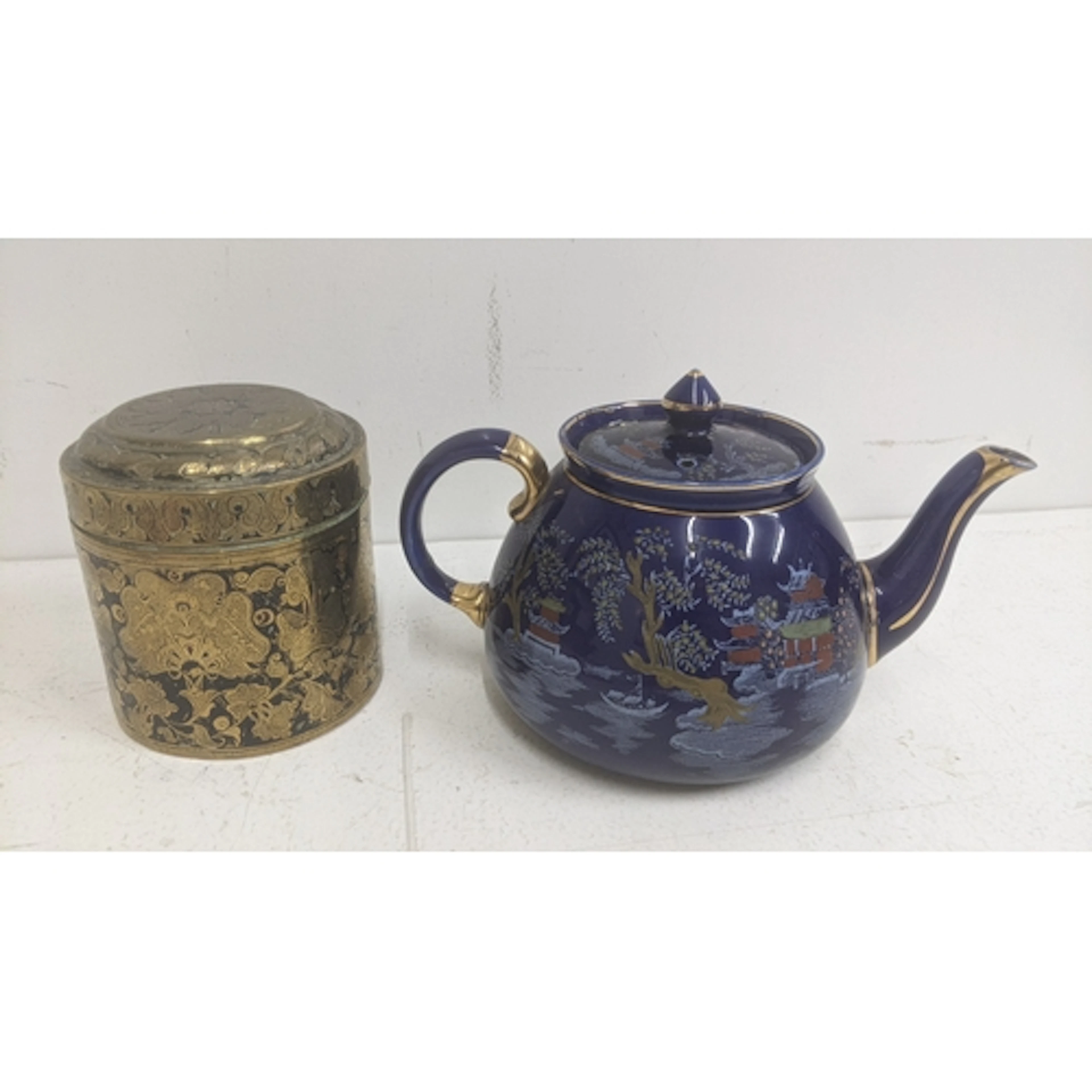 A vintage lipped brass tea caddy with a decorative design, a...
