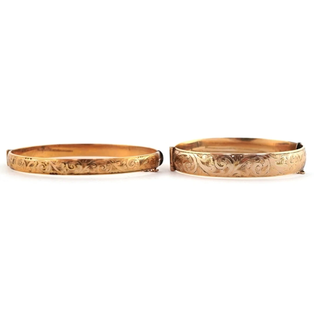 Two 9ct gold bronze core hinged bangles with engraved decora...