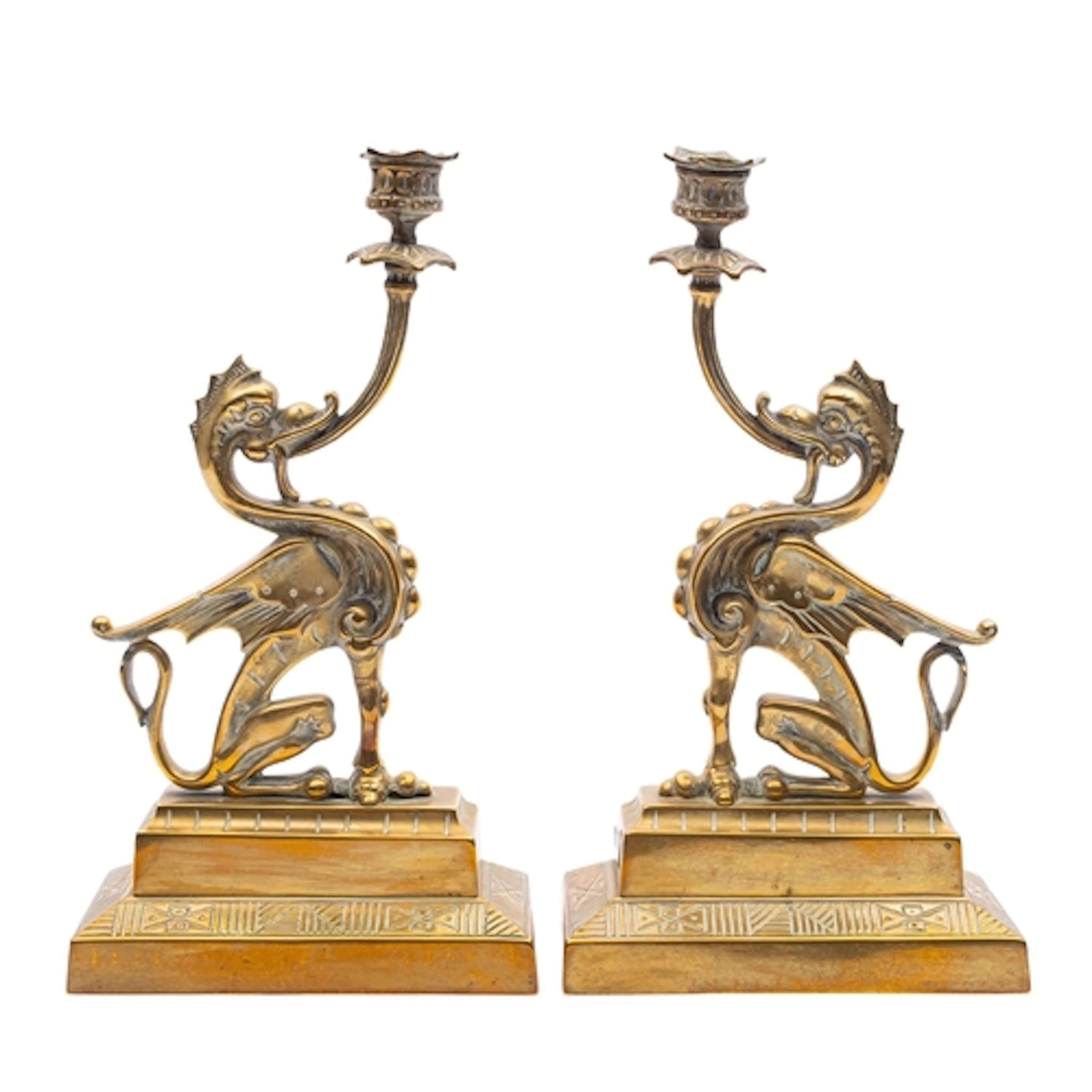 A pair of Victorian brass candle holders cast with seated gr...