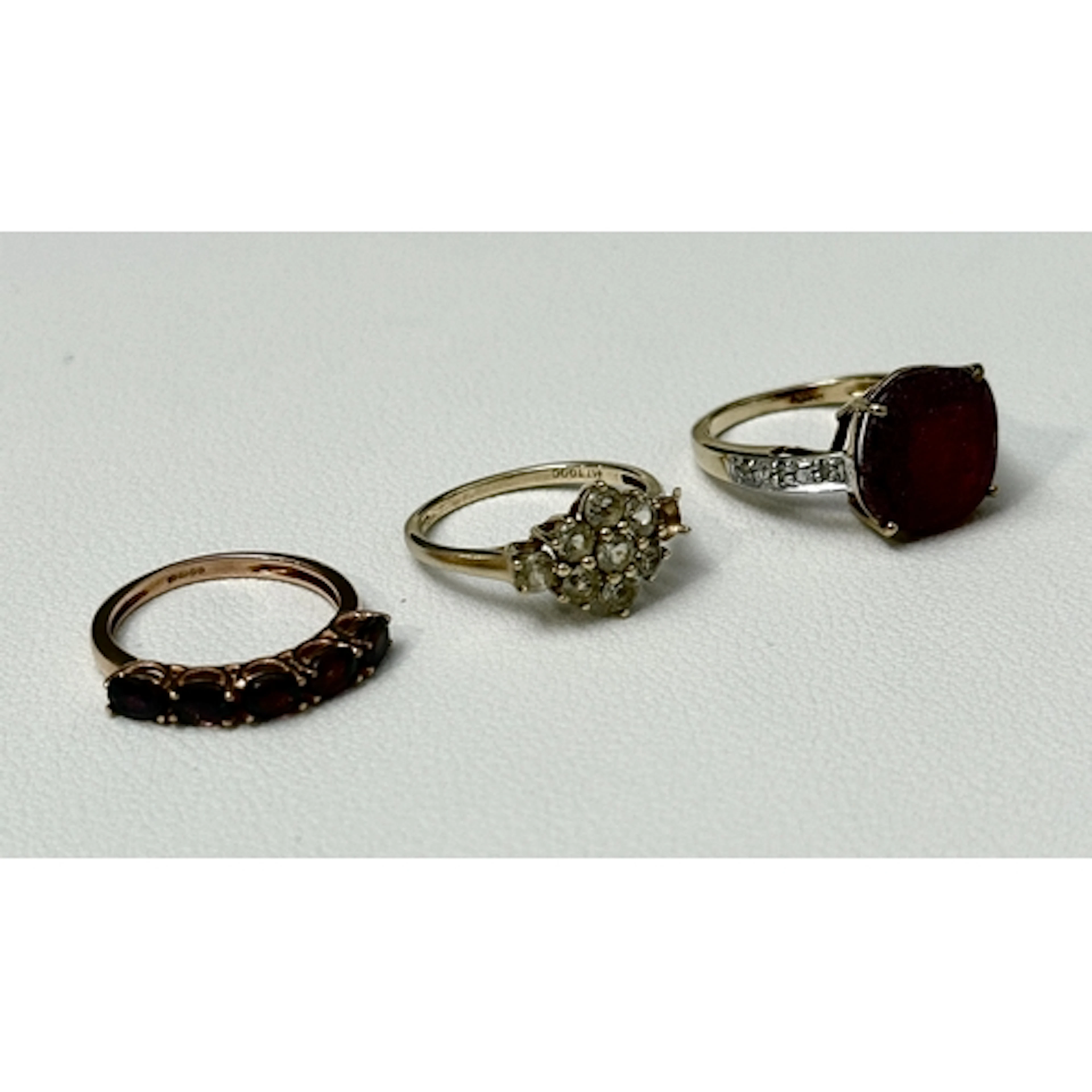 Three 9ct yellow gold and gemstone rings - all UK hallmarked...
