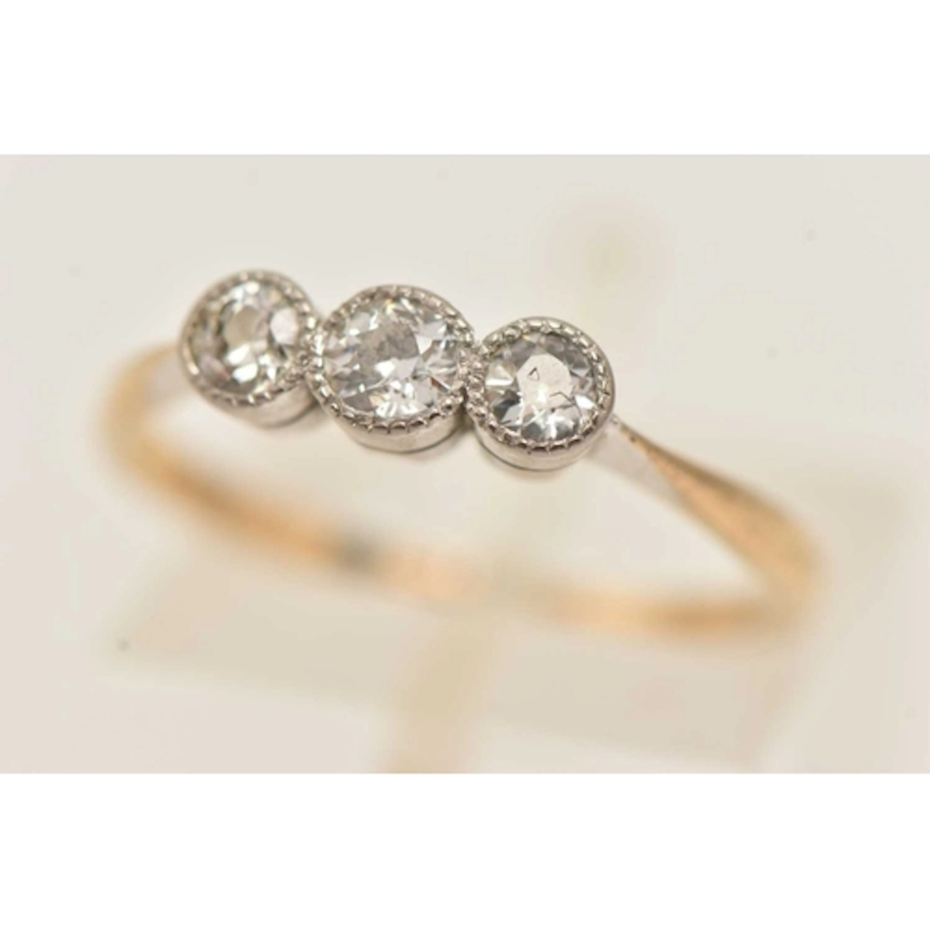 A YELLOW METAL THREE STONE DIAMOND RING, three old cut diamo...