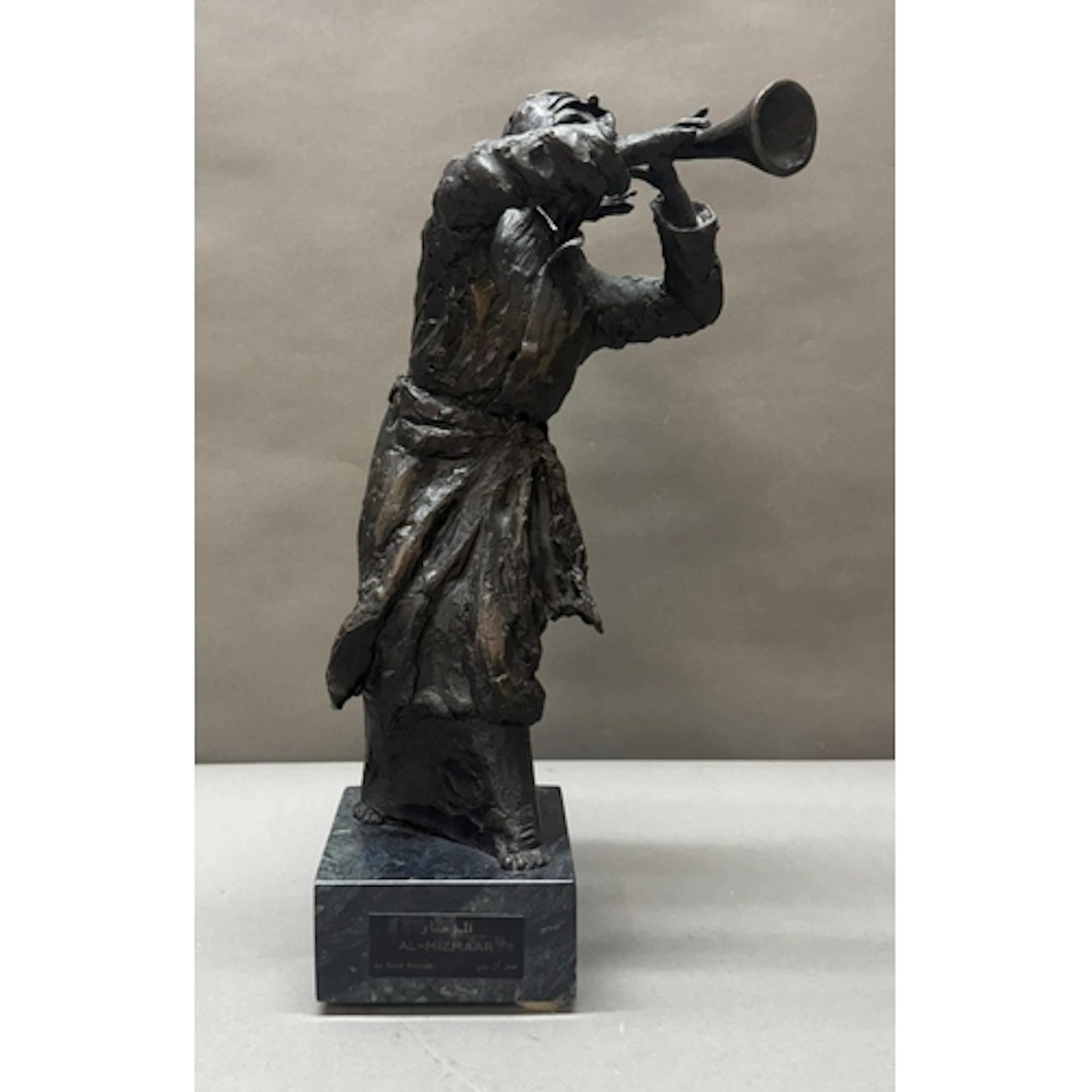 A bronze effect sculpture of a young man playing the trumpet...