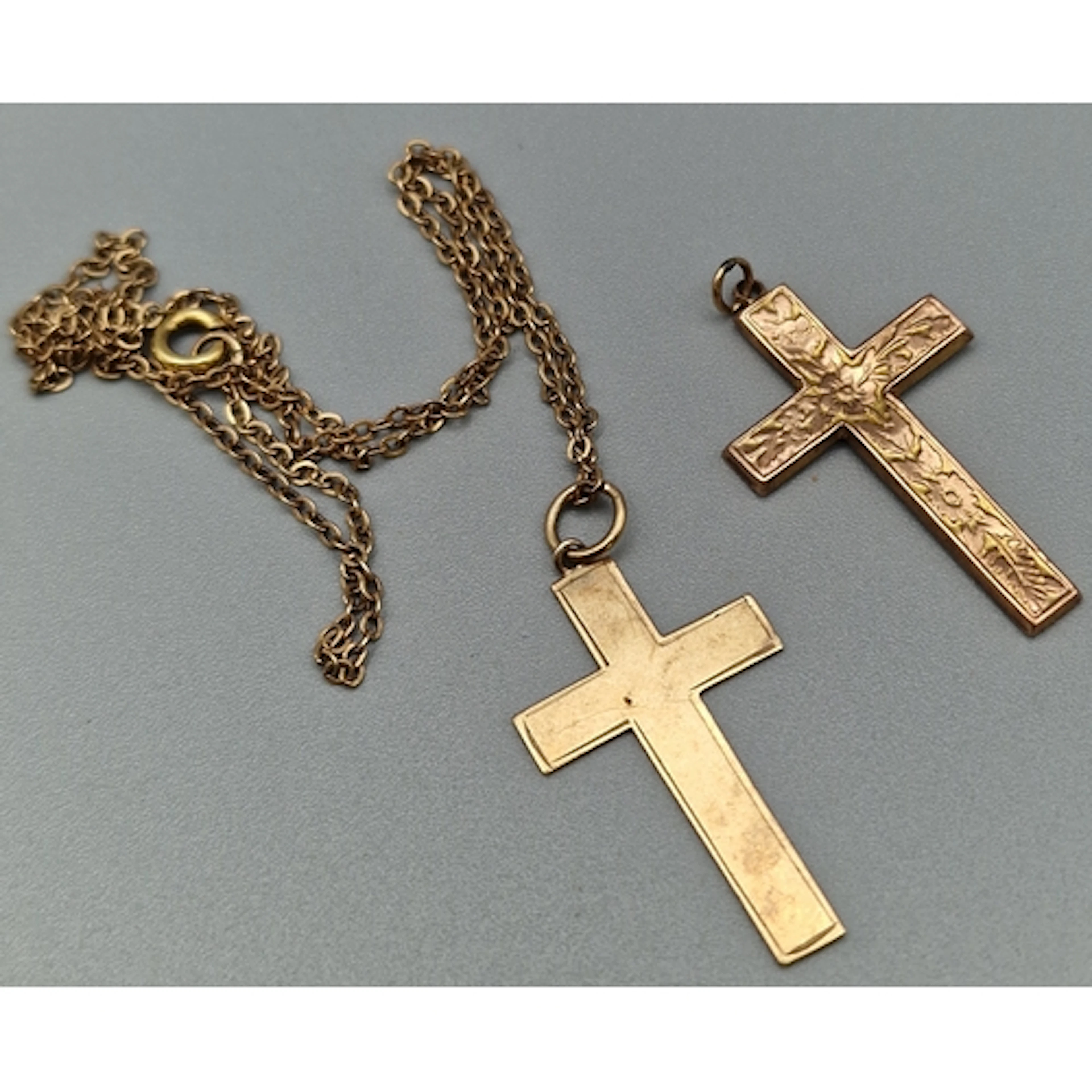 Two 9ct gold crucifix pendants, together with a yellow metal...