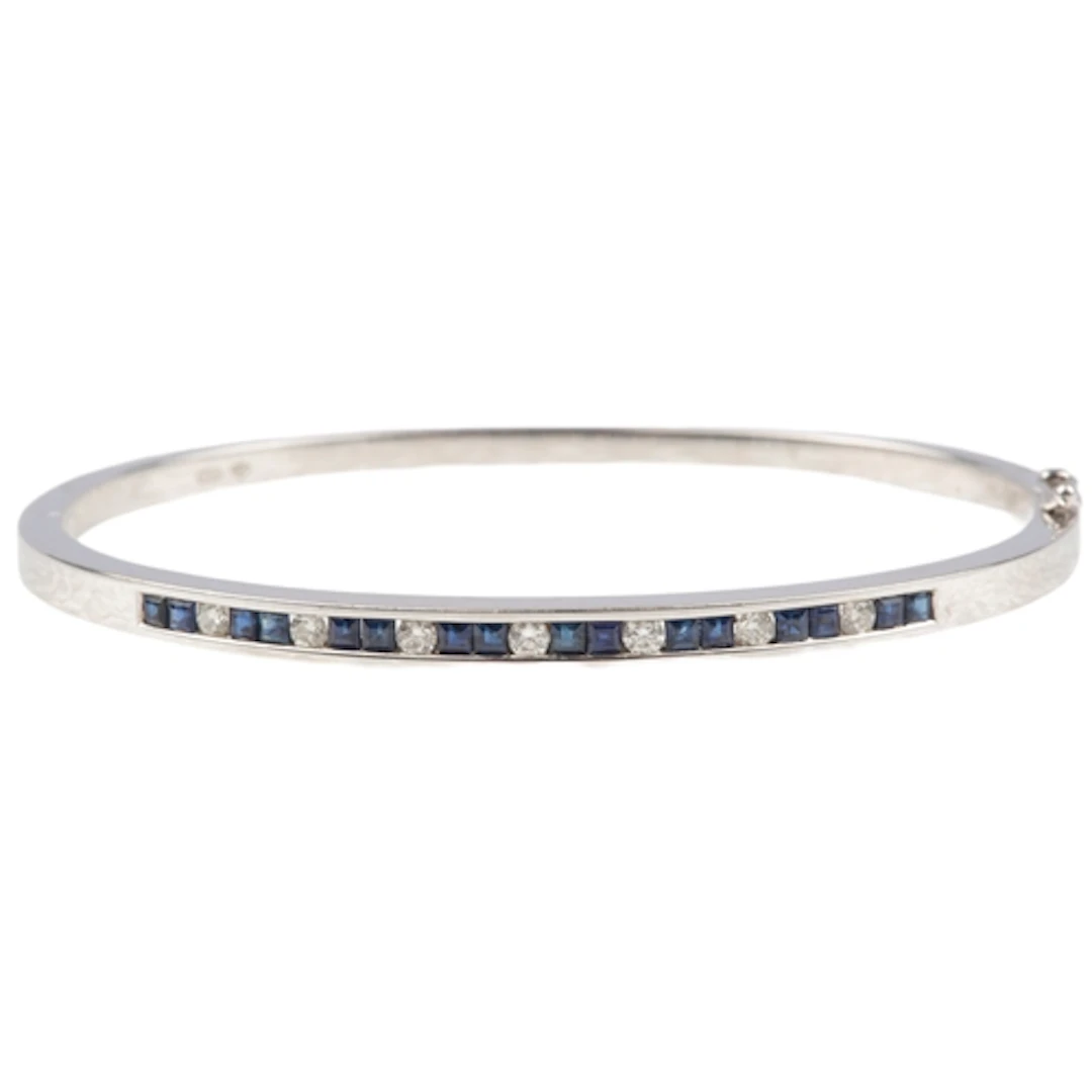 A sapphire and diamond bangle, of hinged construction, the f...
