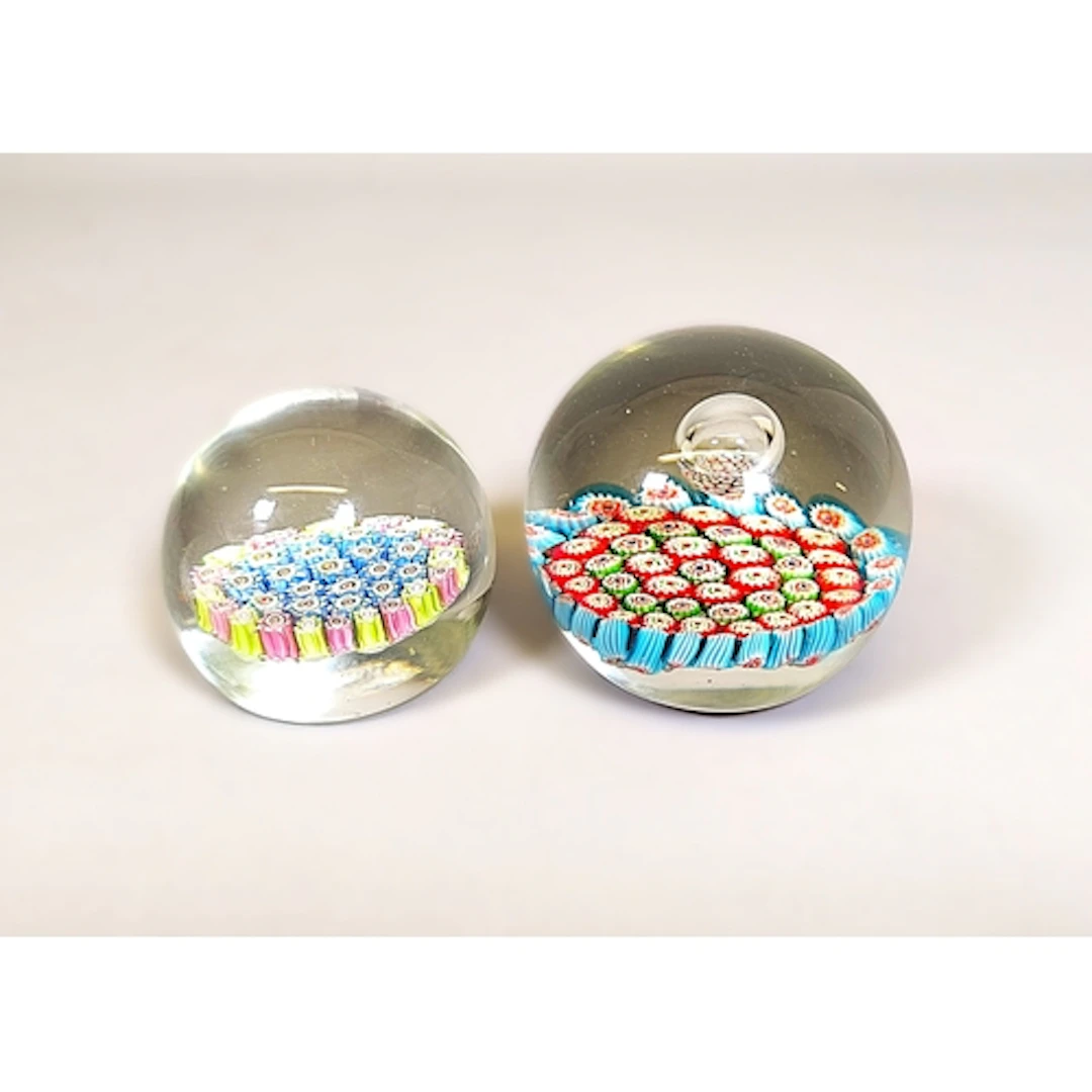 Two vintage millefiori glass paperweights, Designed with mul...