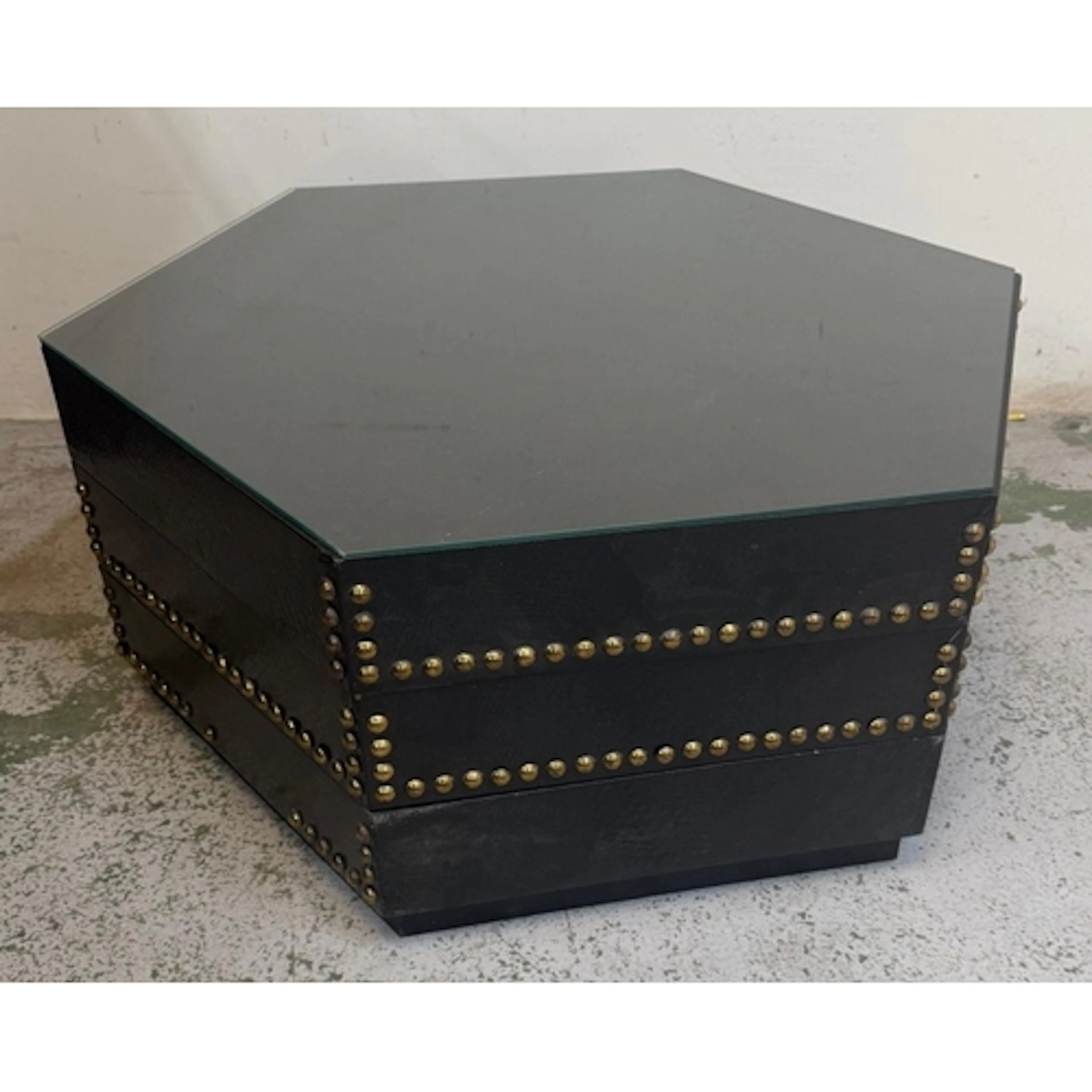 A contemporary hexagonal glass topped coffee table with bras...