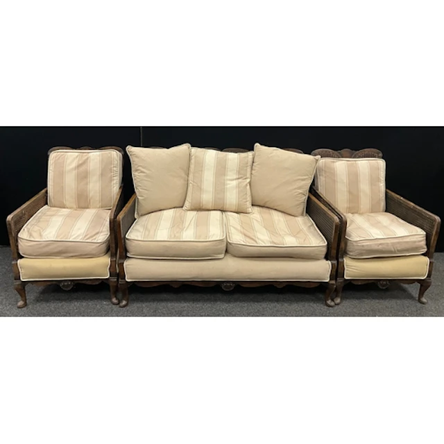 An early 20th century three-piece bergère lounge suite, wove...
