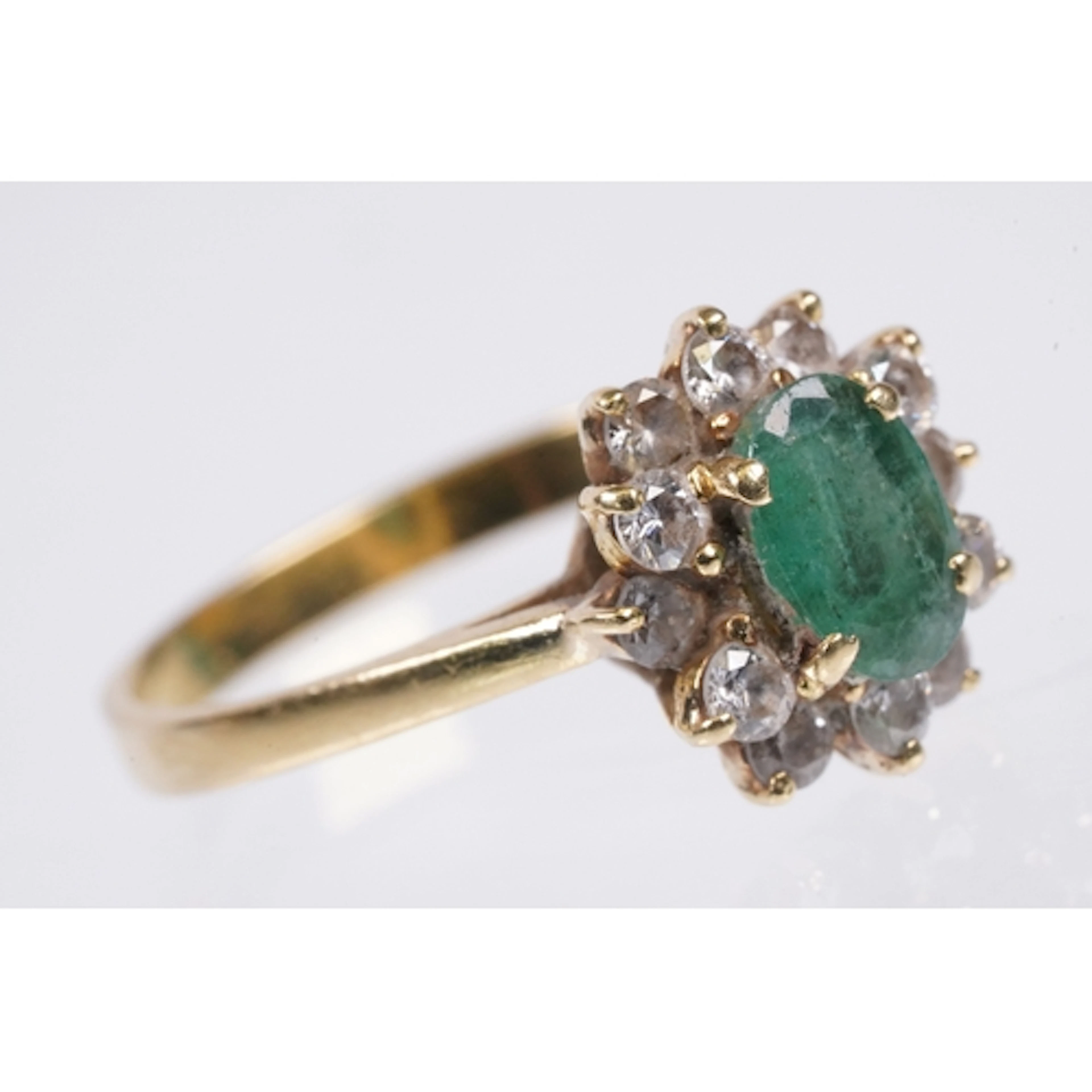 18ct gold, emerald and diamond ring. The ring being set with...