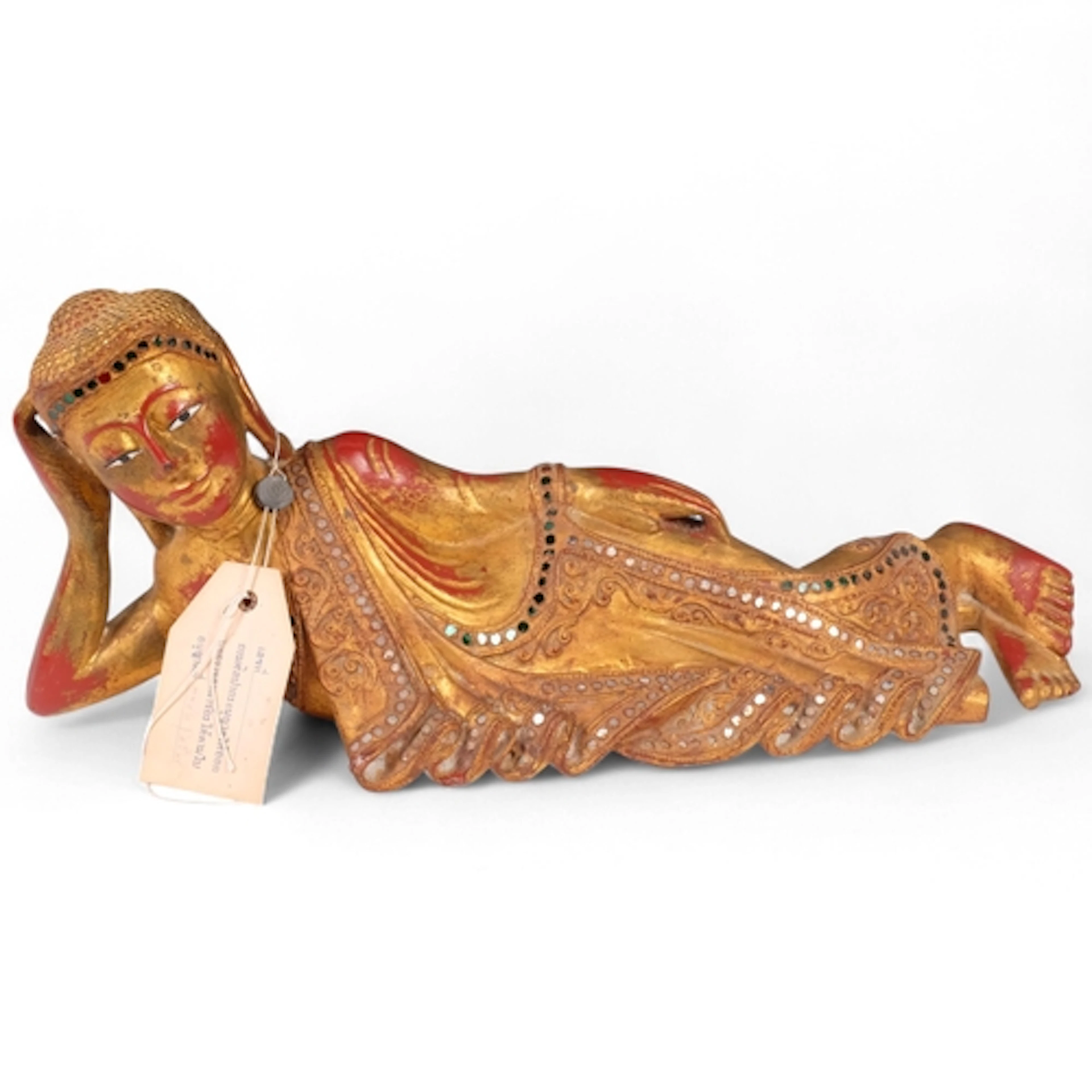 A Thai carved painted and gilded reclining figure, with colo...