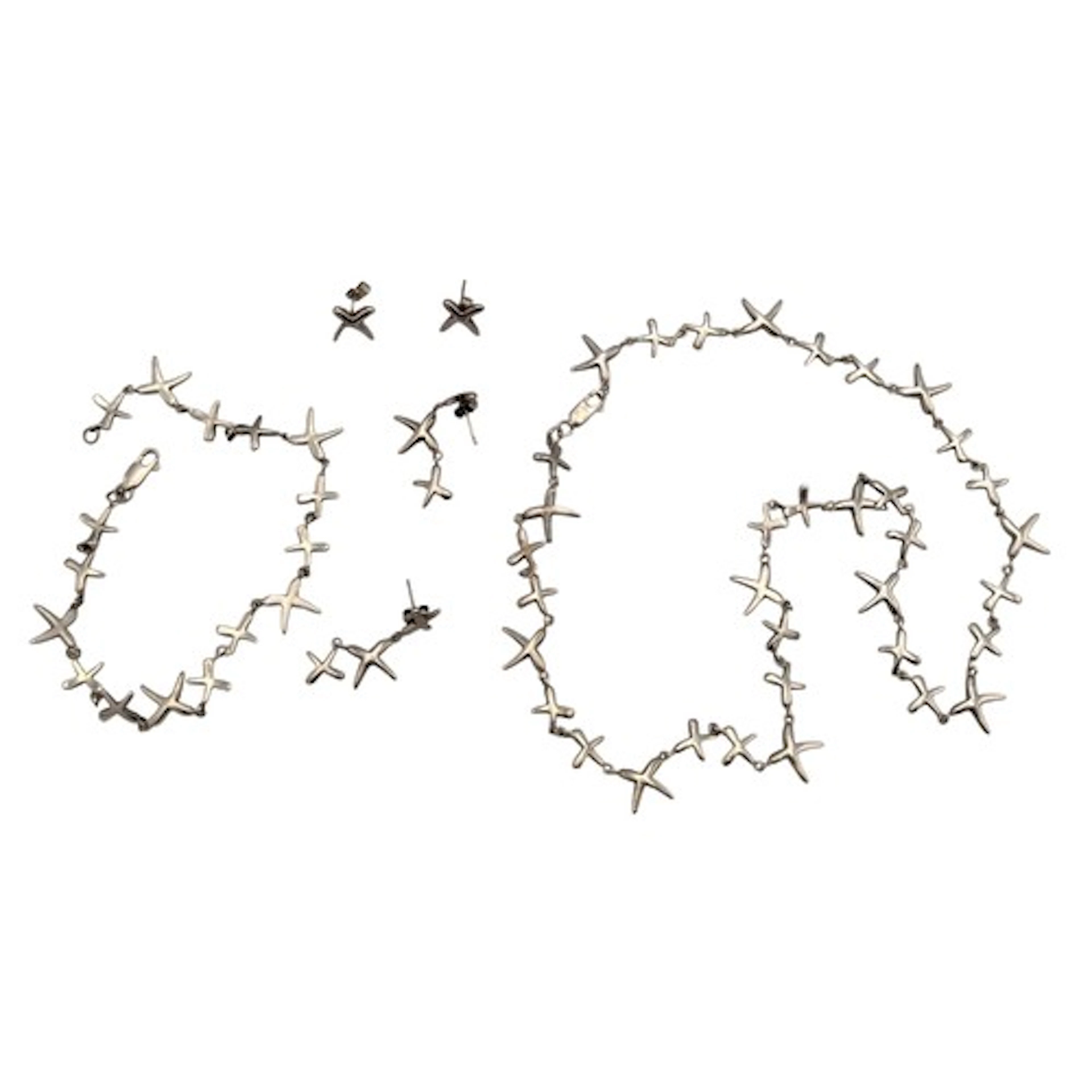 A silver and unmarked silver metal necklace, bracelet and ea...