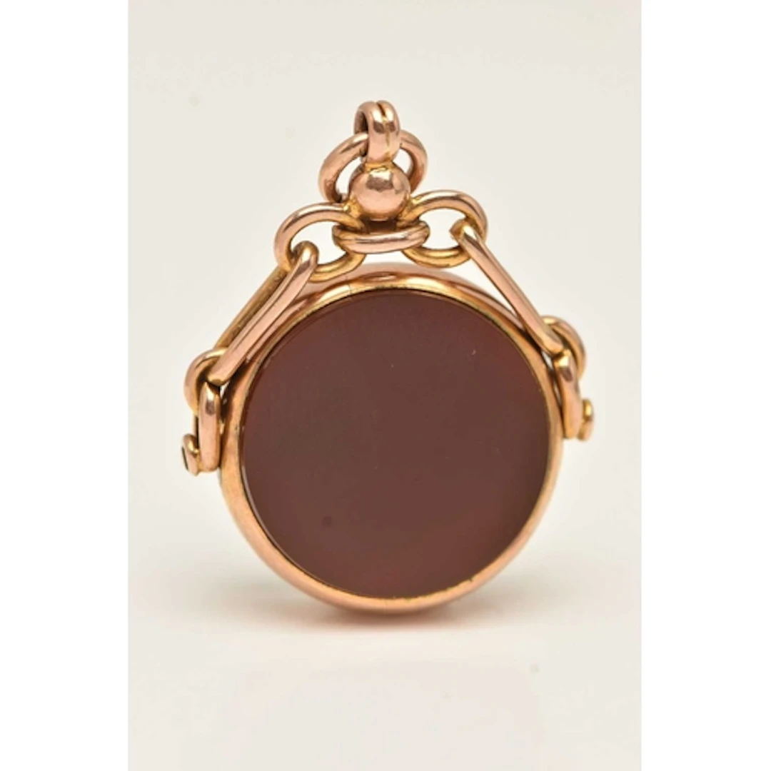 A 9CT YELLOW GOLD SPINNING FOB, a circular form fob, inlay s...