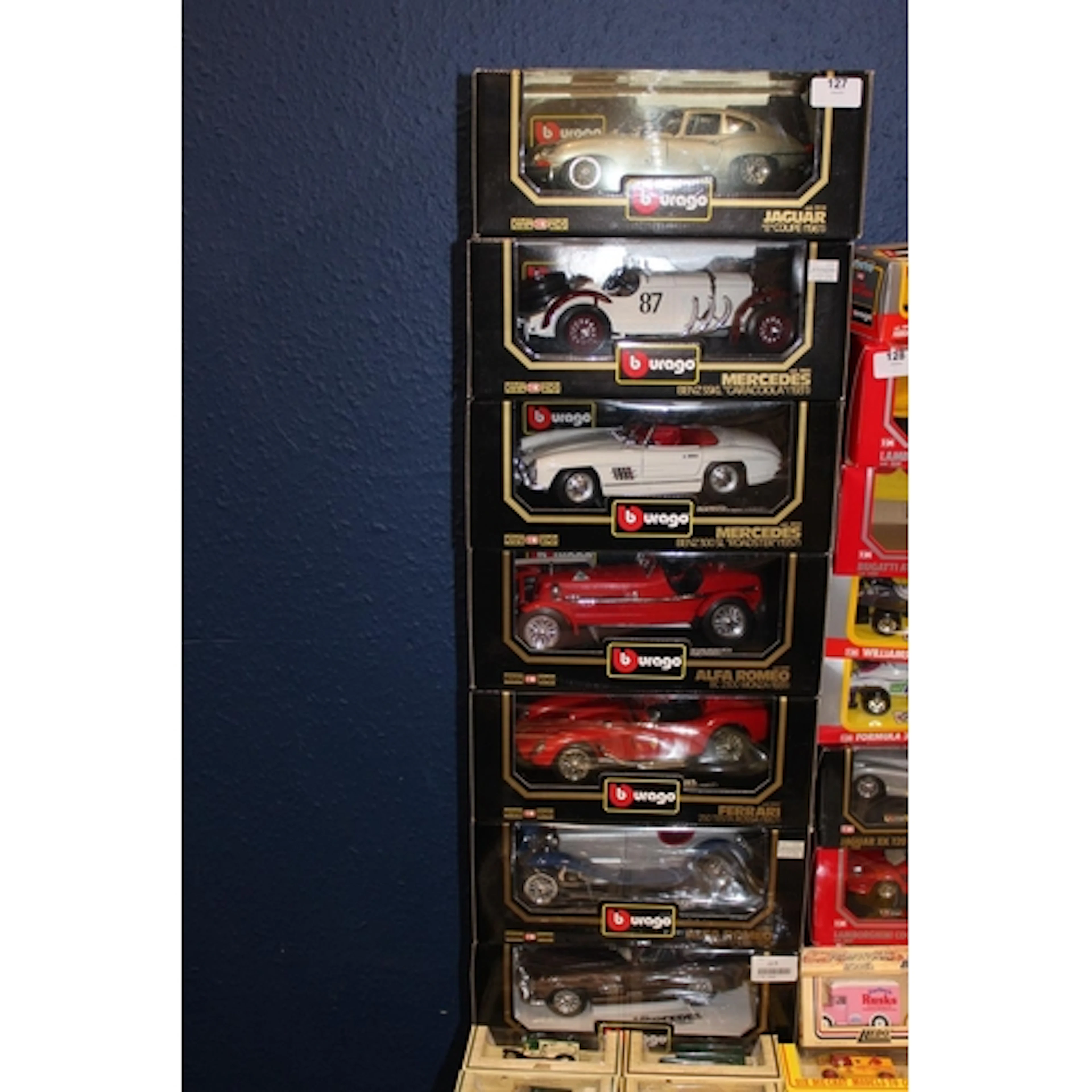 Seven Burago 1:18 scale diecast model vehicles to include 30...