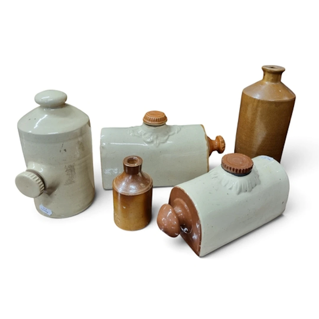 A collection of antique stoneware bottles comprising a Holli...
