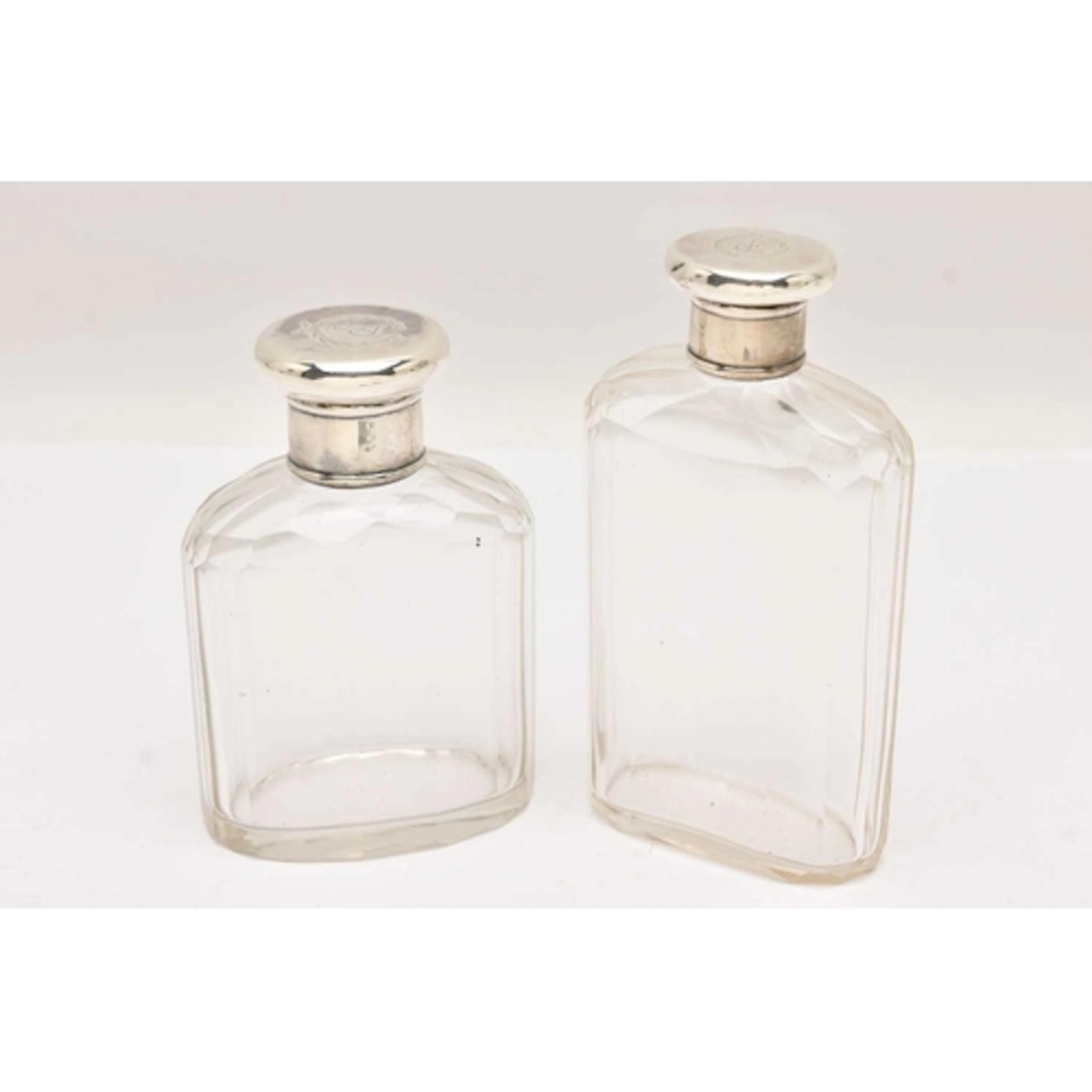TWO EARLY 20TH CENTURY, GLASS BOTTLES WITH SILVER COVERS, fa...