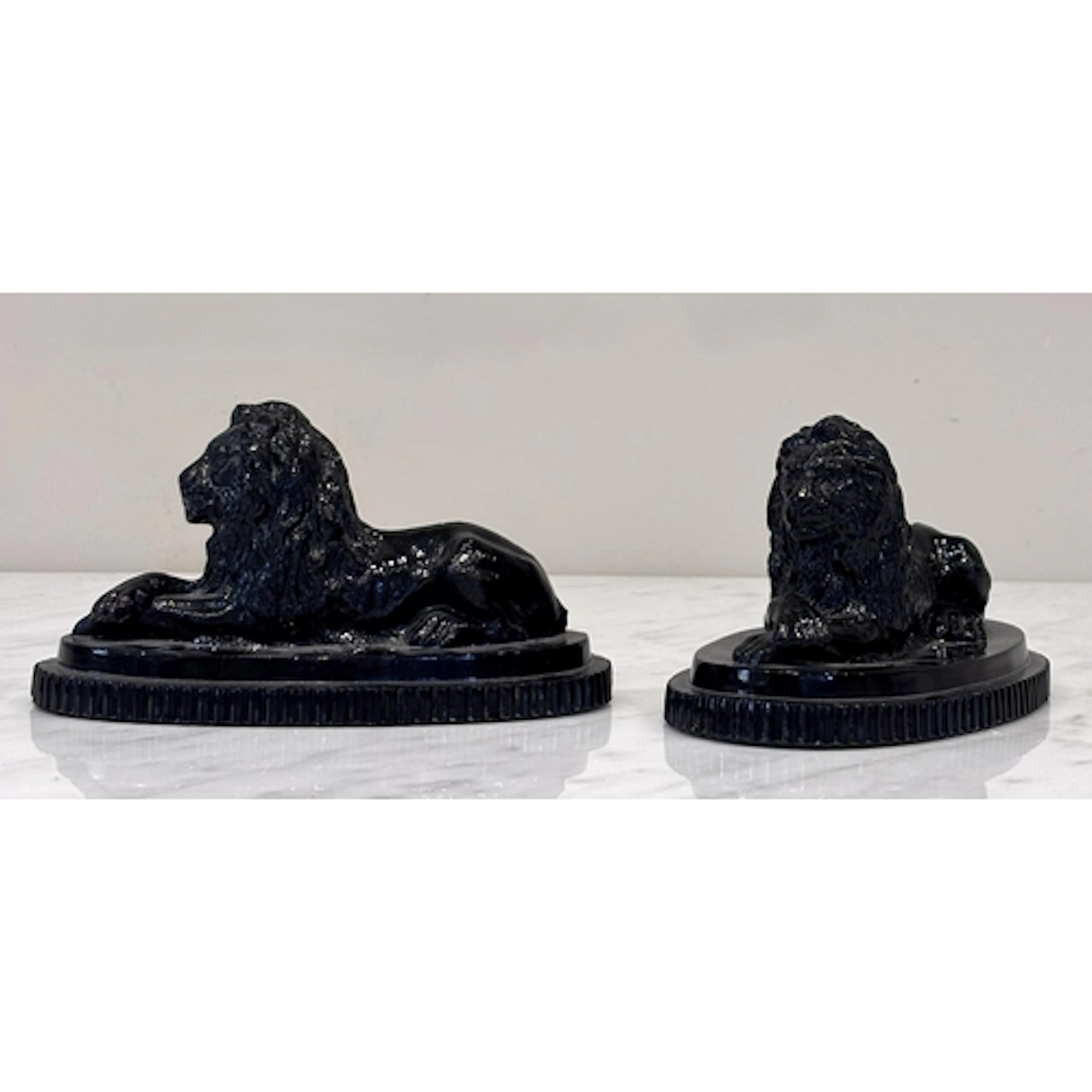 A pair of pressed glass recumbent lions, John Derbyshire, ea...