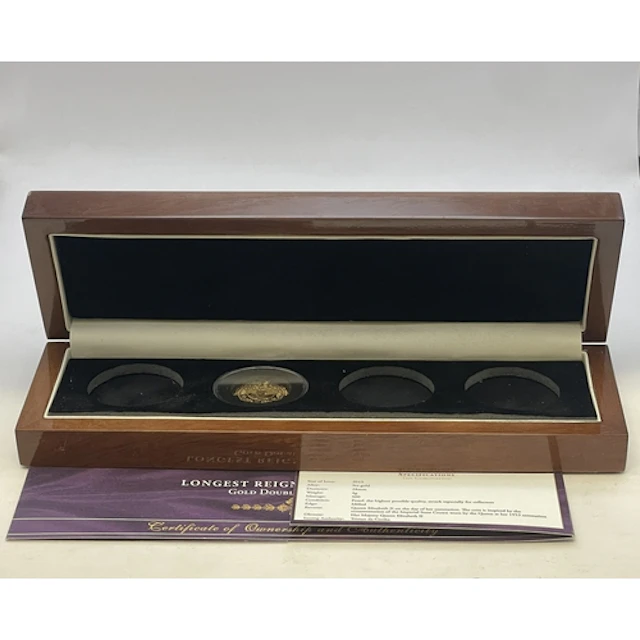 A boxed Longest Reigning Monarch Gold Double Crown Set with ...