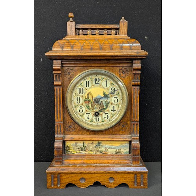 An Arts & Crafts style mantel clock, the dial and lower pane...
