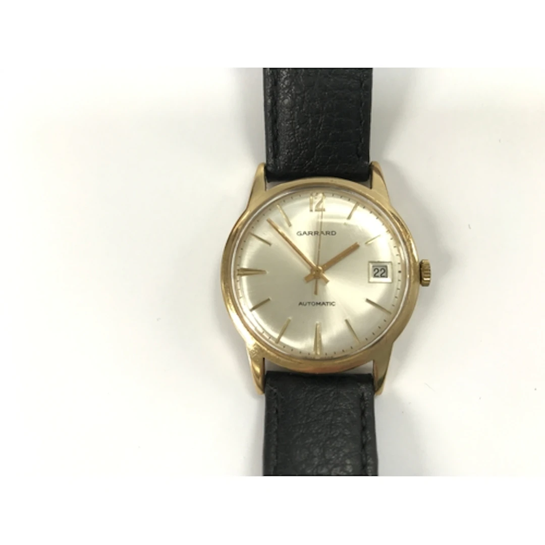 A 9k gold gents Garrard wrist watch with box. Winds and runs...