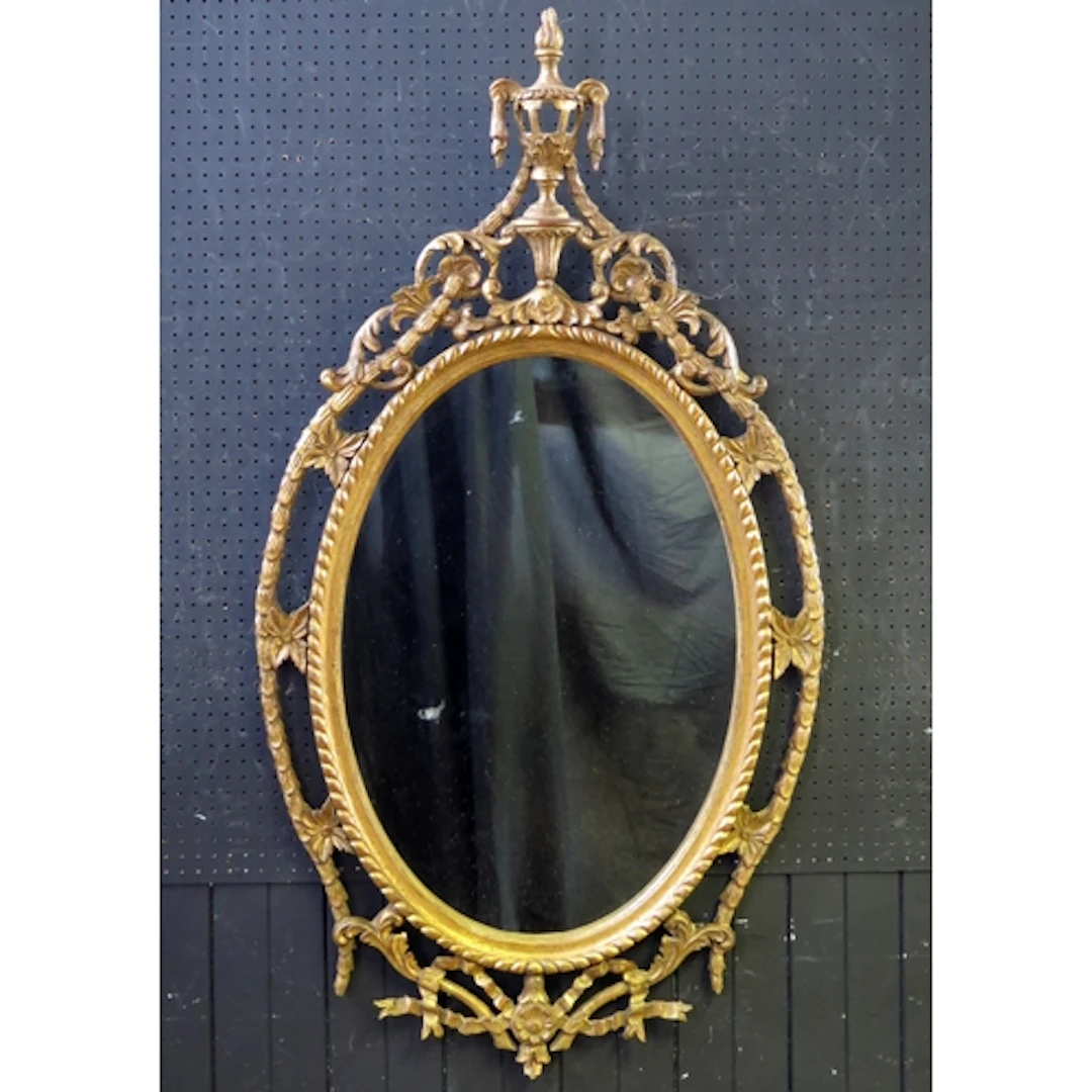 An Italian giltwood mirror, the oval mirror plate enclosed ...