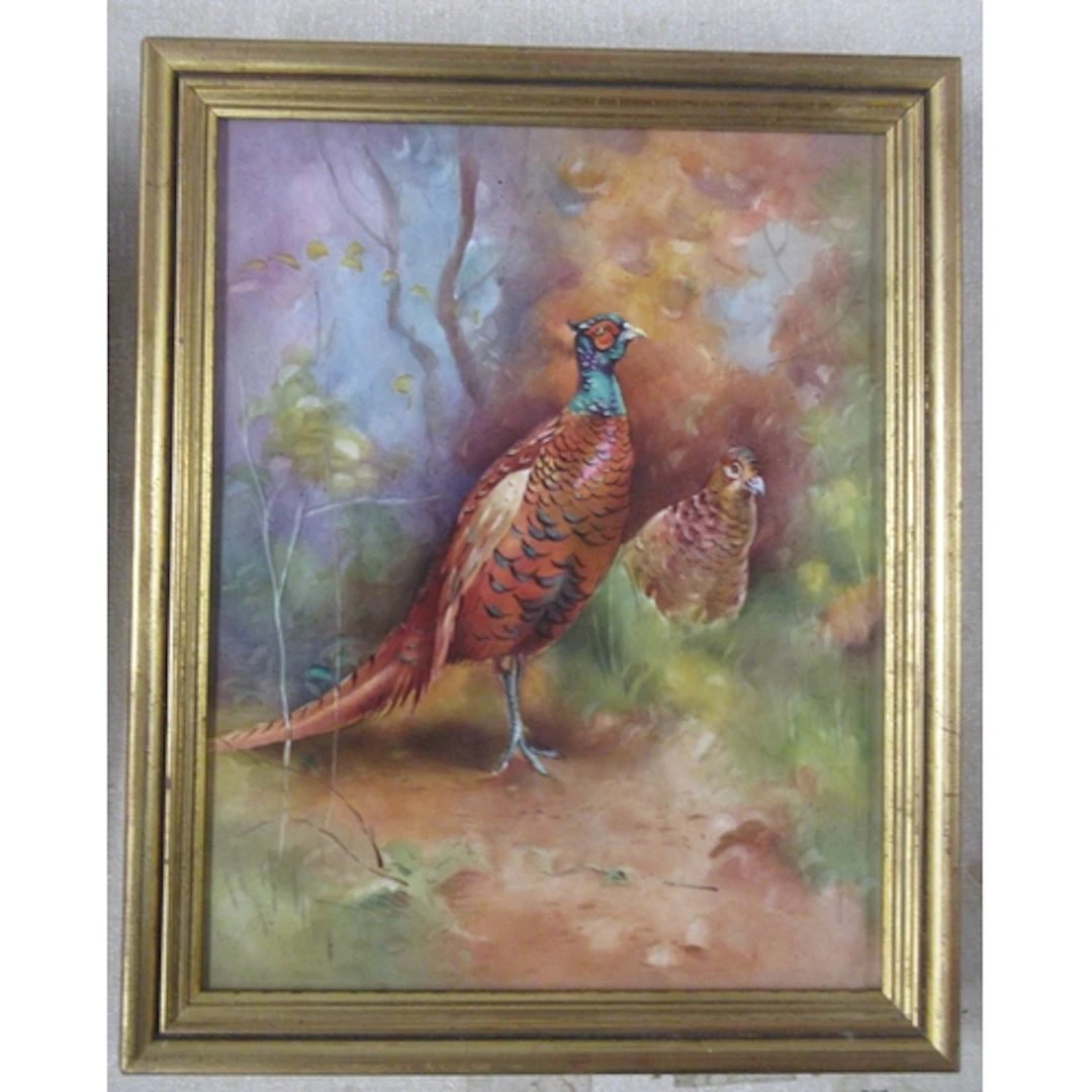 A framed porcelain plaque, decorated with a pheasants in lan...