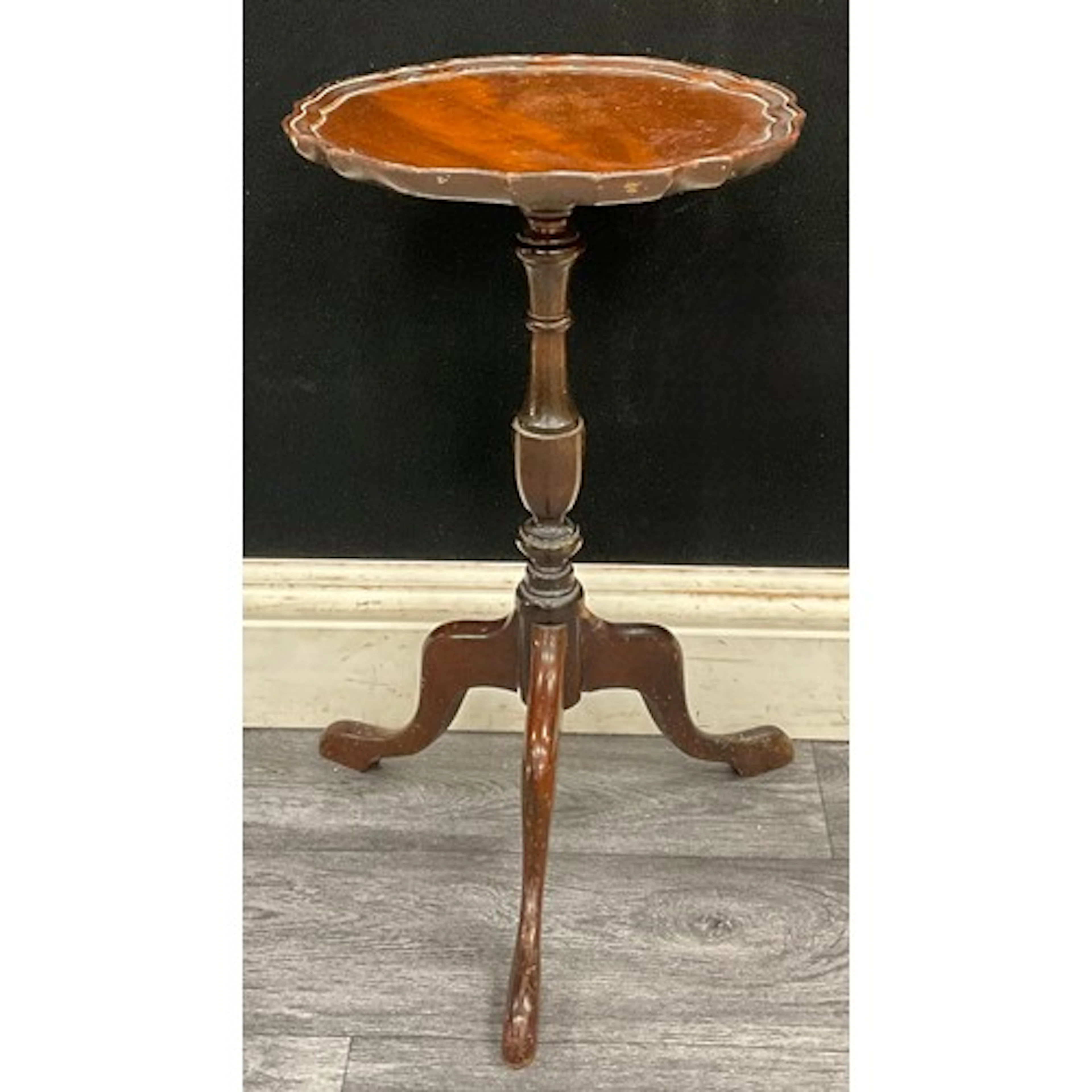 A late Victorian wine table with piecrust top on swept cabri...