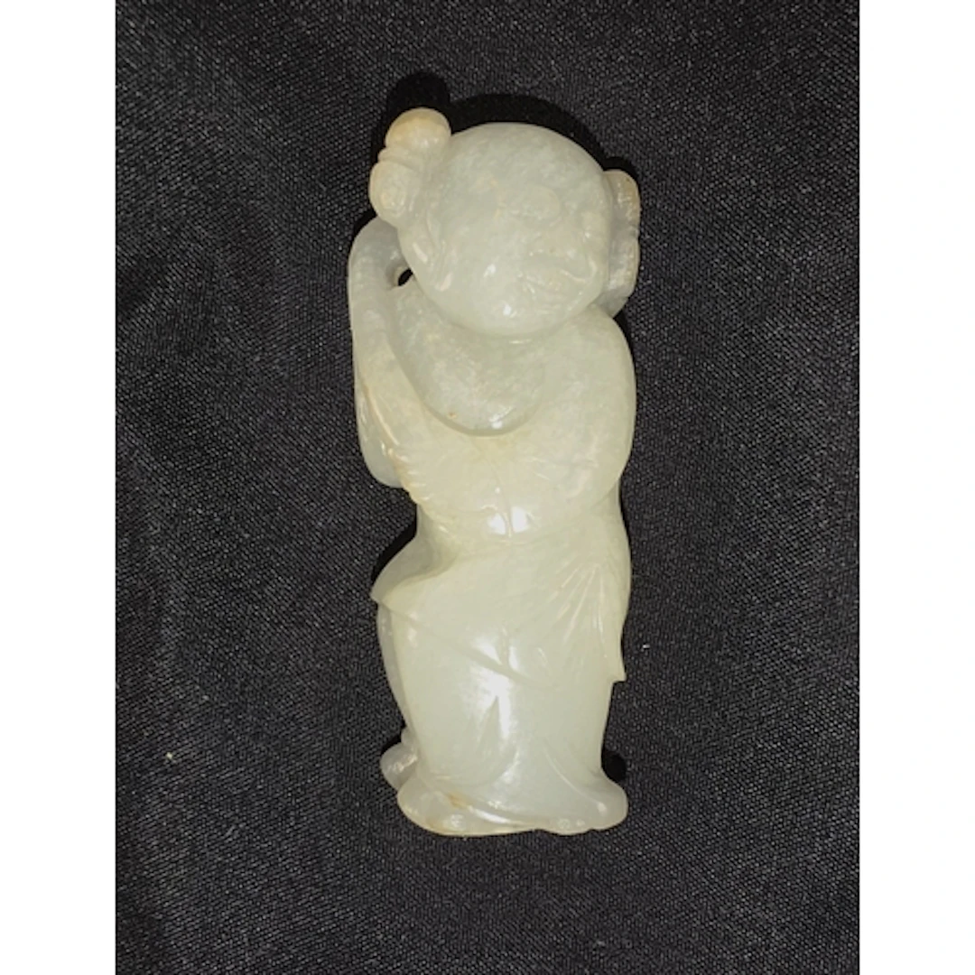 A Chinese Qing period Jade carving of boy holding flower, 5....