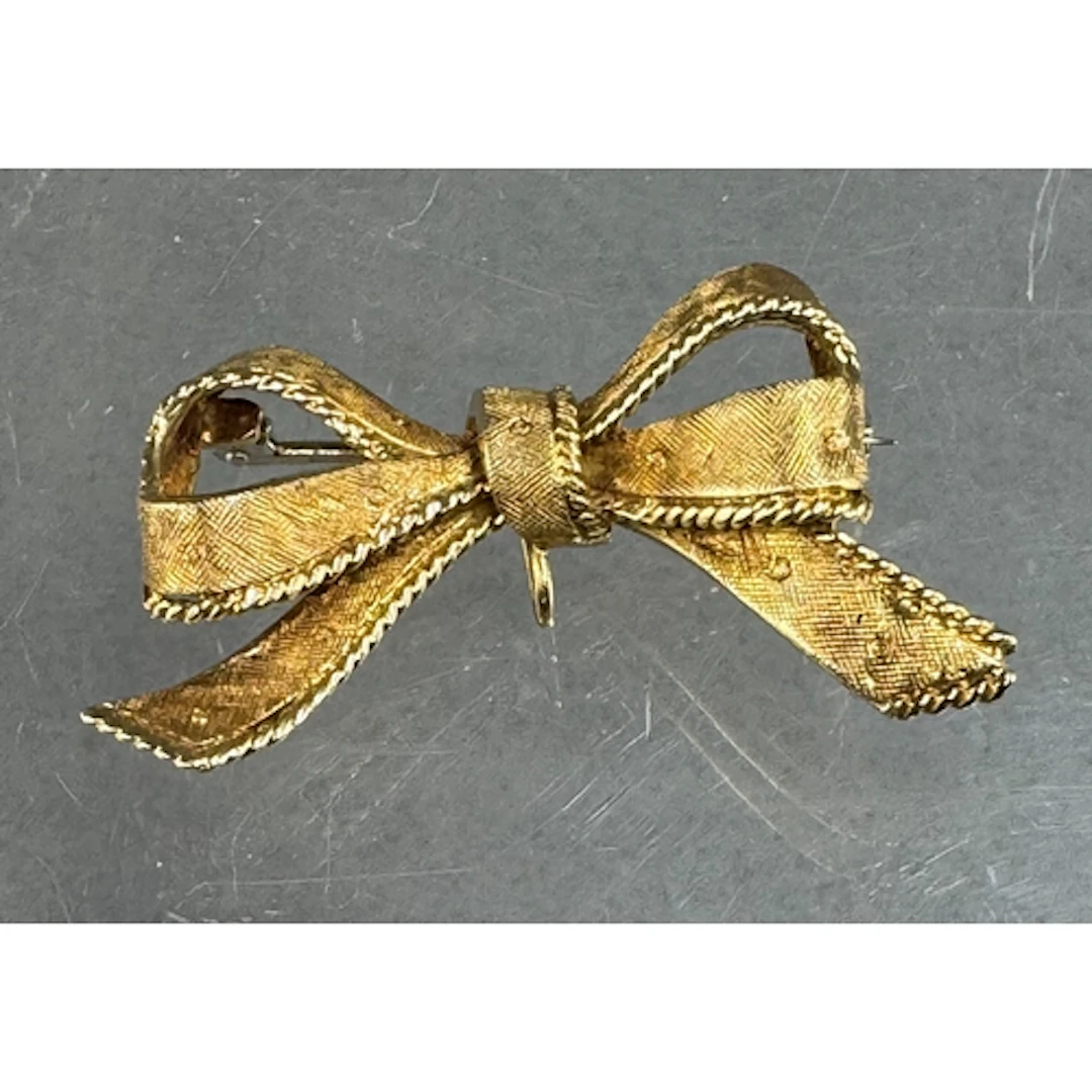Jewellery: an 18ct yellow gold bow brooch with pendant suspe...